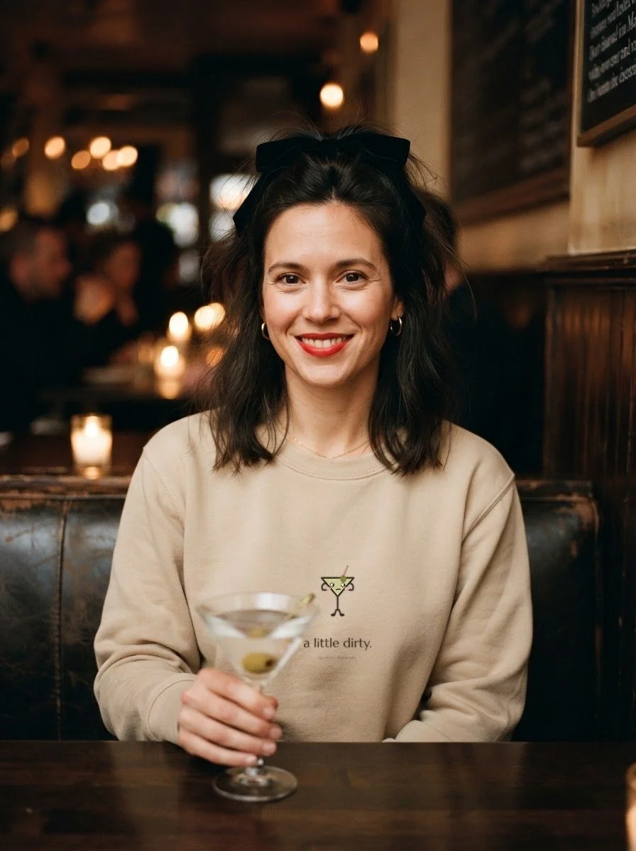 Woman in a candlelit booth in a Sand Filthy, Please crewneck