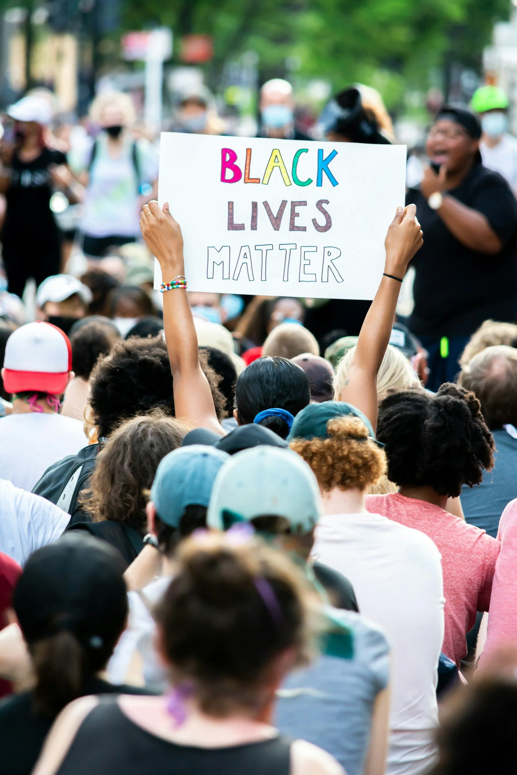 black lives matter sign being held up in a crowd of people