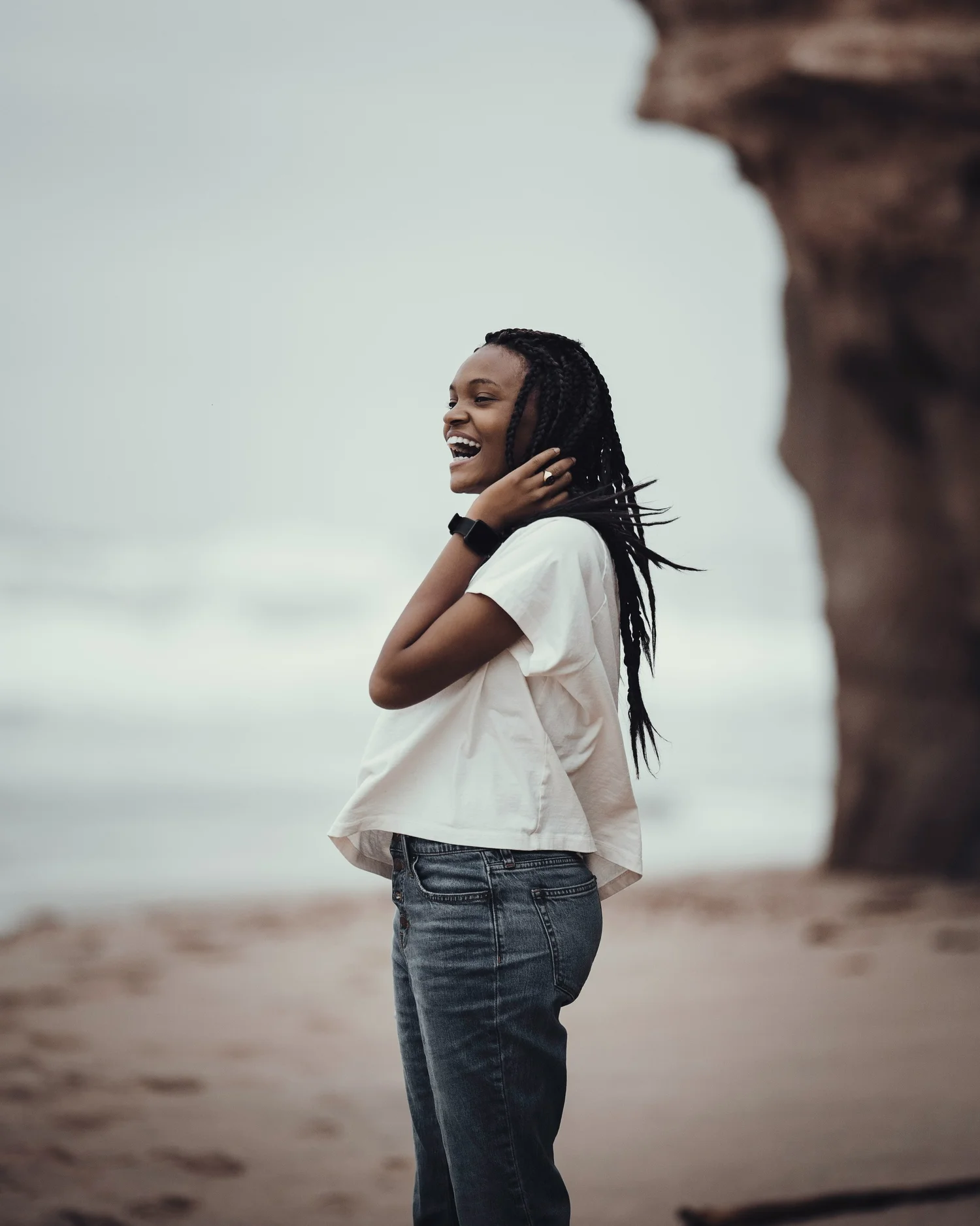 A joyful woman on a beach, representing the lightness and relief clients feel after IFS therapy sessions at Full Self Psychotherapy in Washington DC