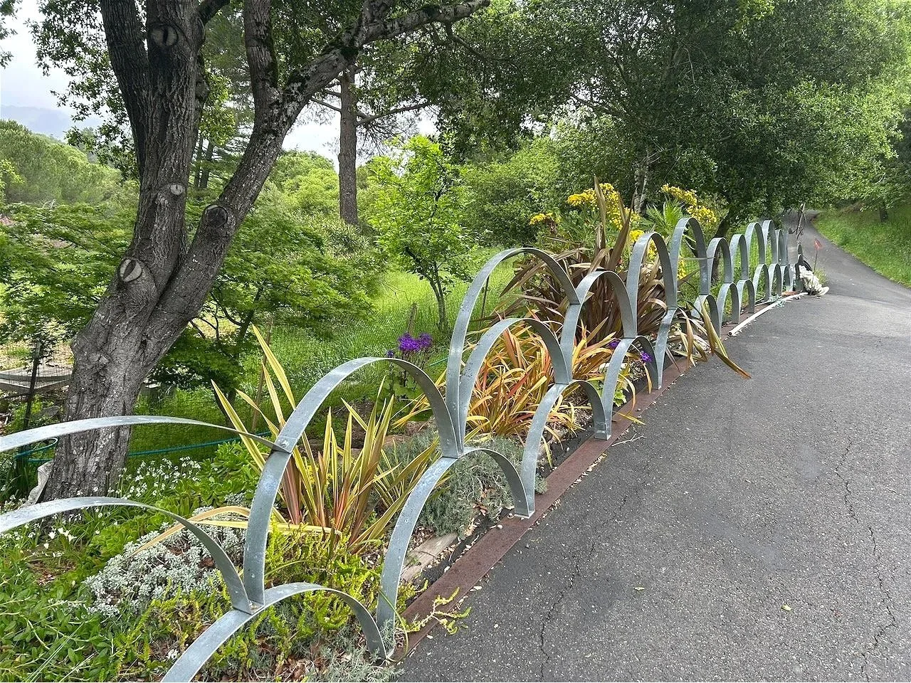 The differing bands of metal, joined at the base, tiered here and there.  Placed at the edge of the asphalt, they began to lean inward over time.  I added lengths of steel plate to unify them and drove longer lag screws into the ground...I misused th
