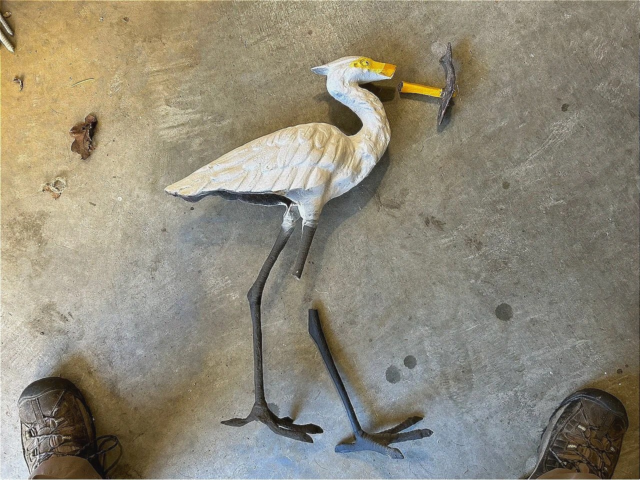 A find from a friend's burned home remains.  It was a simple cast iron (like the fish in its mouth) painted up.  The attempts to repair the legs and beak (various industrial strength epoxies) gave way to a welding job...