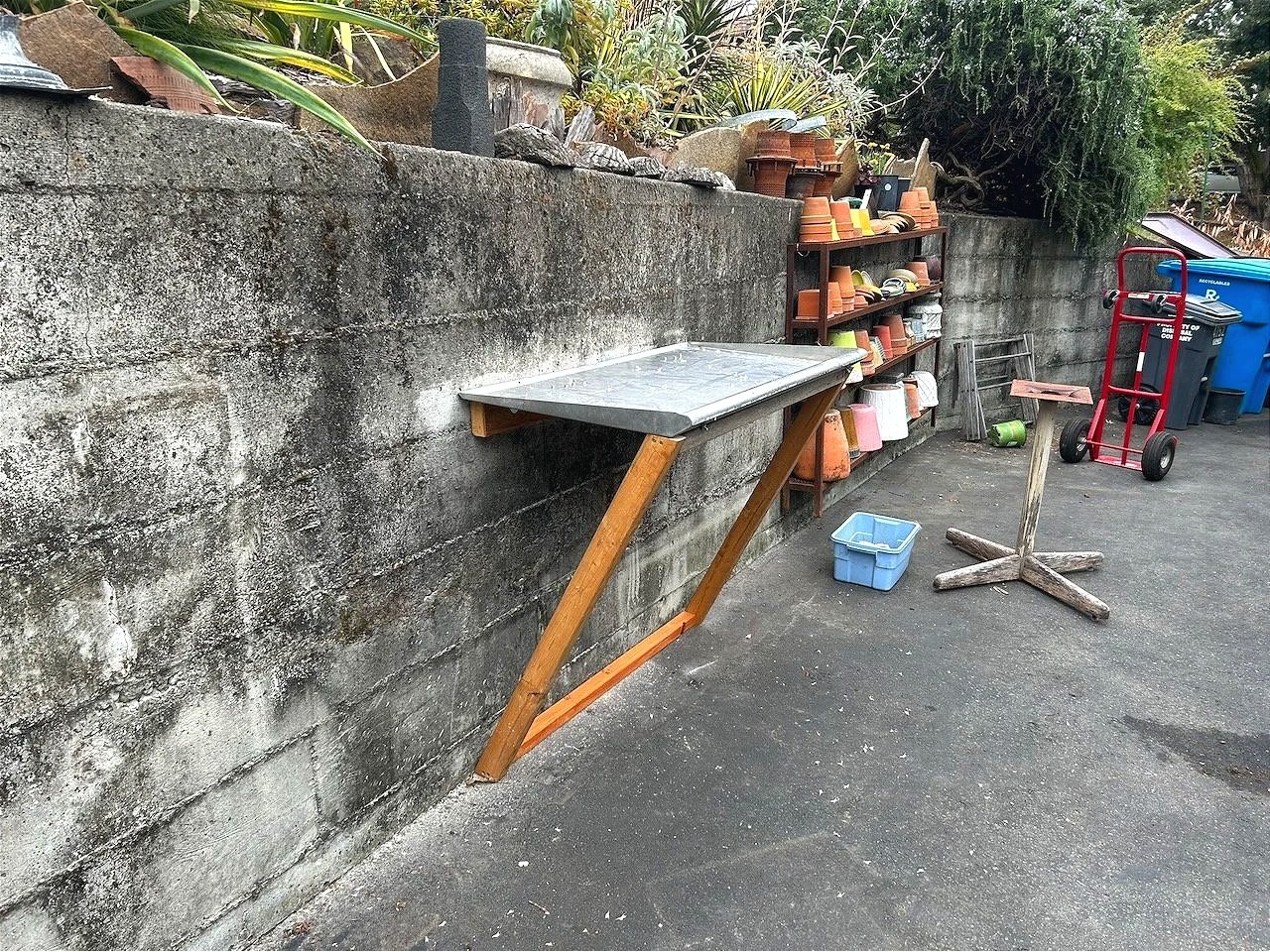 A perfect found stainless surface for a potting bench!...hinged and wood-supported by weight...