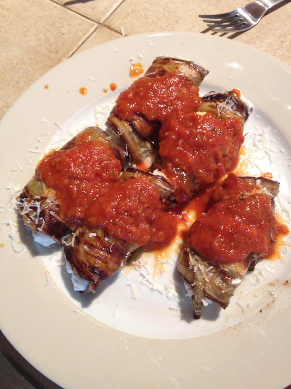 Eggplant, rolled with ricotta, tomato-sauced.