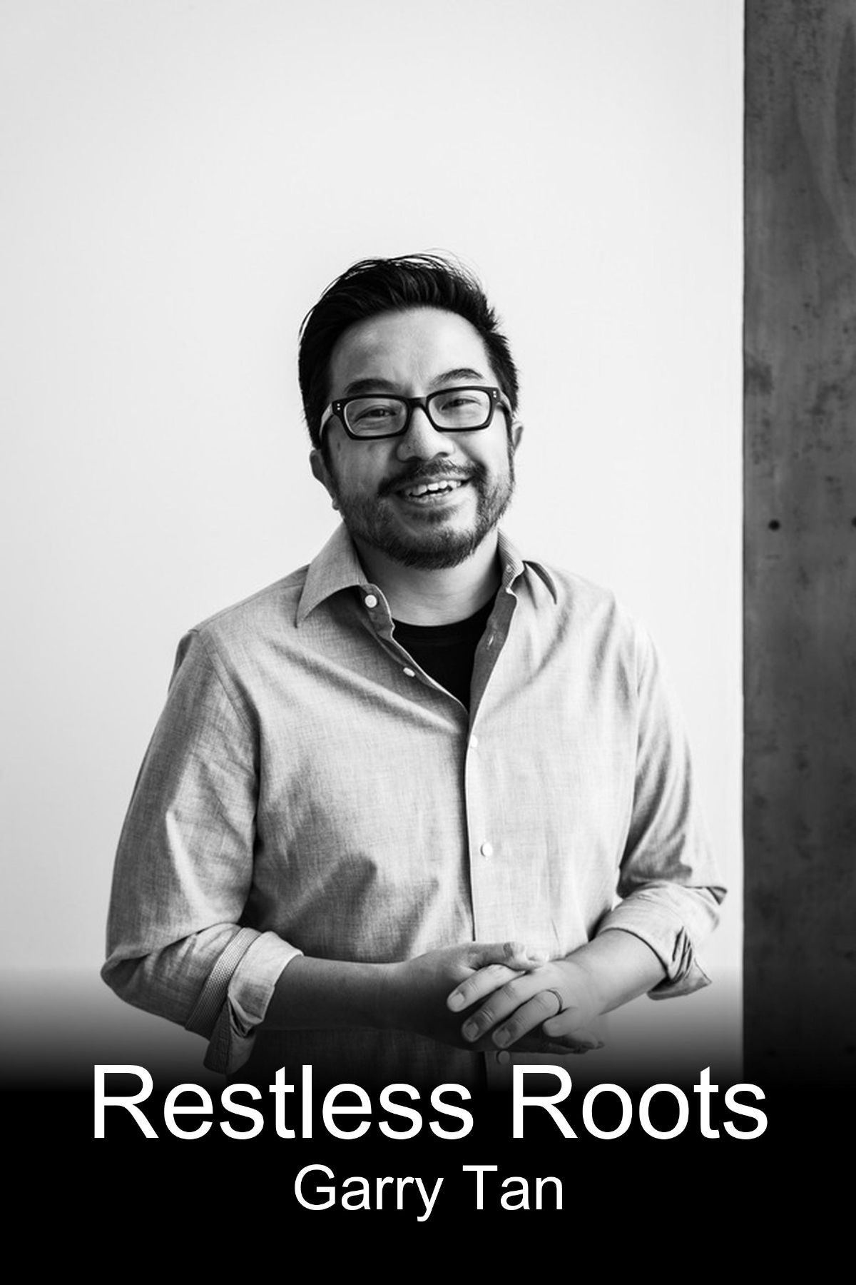 Black and white portrait of Garry Tan wearing glasses, smiling, with a casual button-up shirt, standing against a plain background with a textured wall to the right, and the text 'Restless Roots Garry Tan' at the bottom.