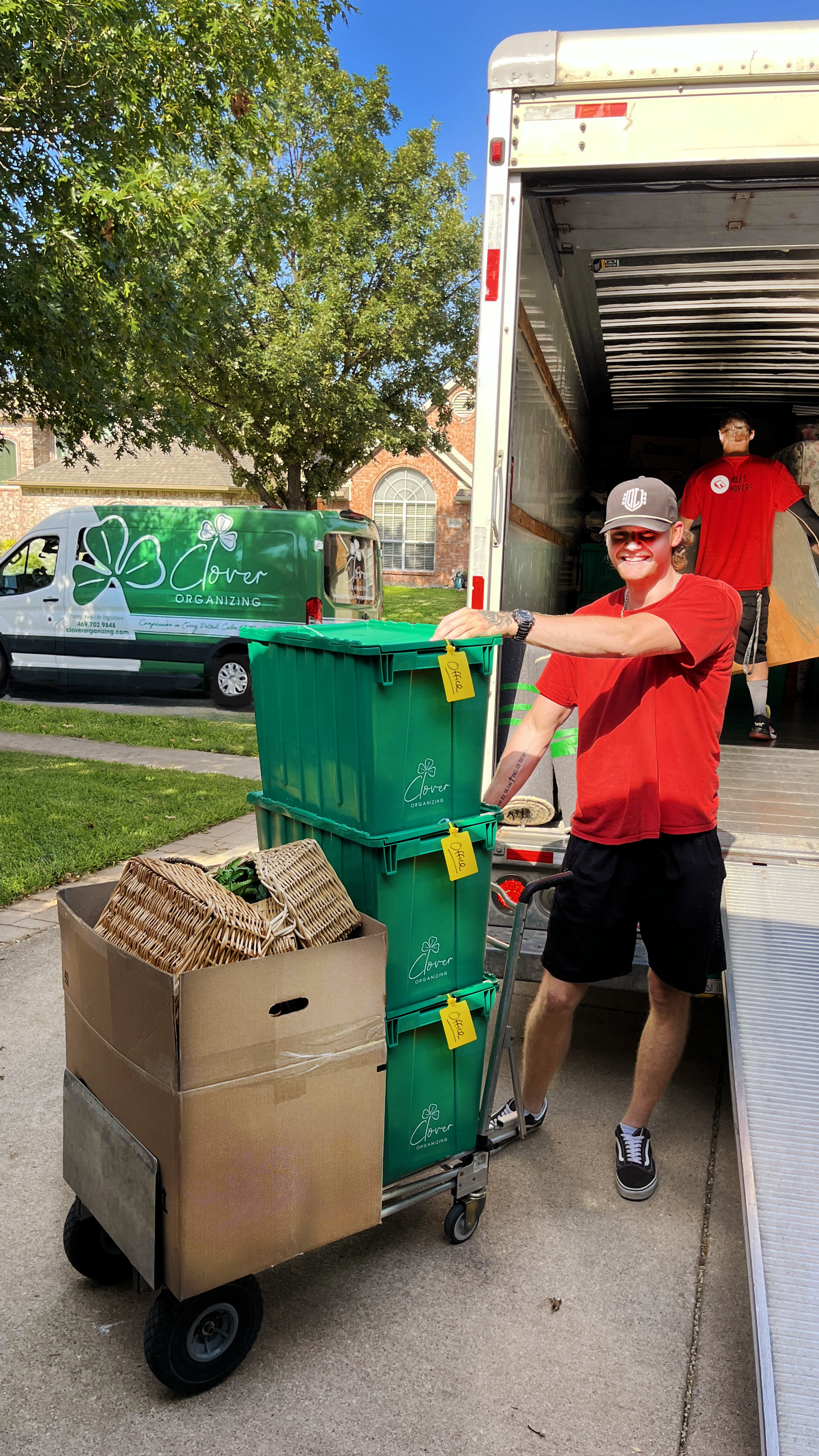 male mover with boxes in front of moving truck