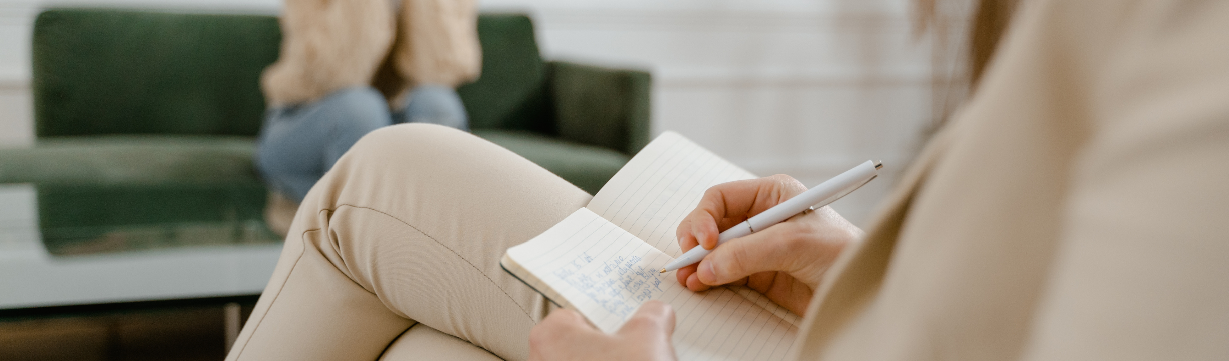 a trauma informed therapist in a therapy session taking notes