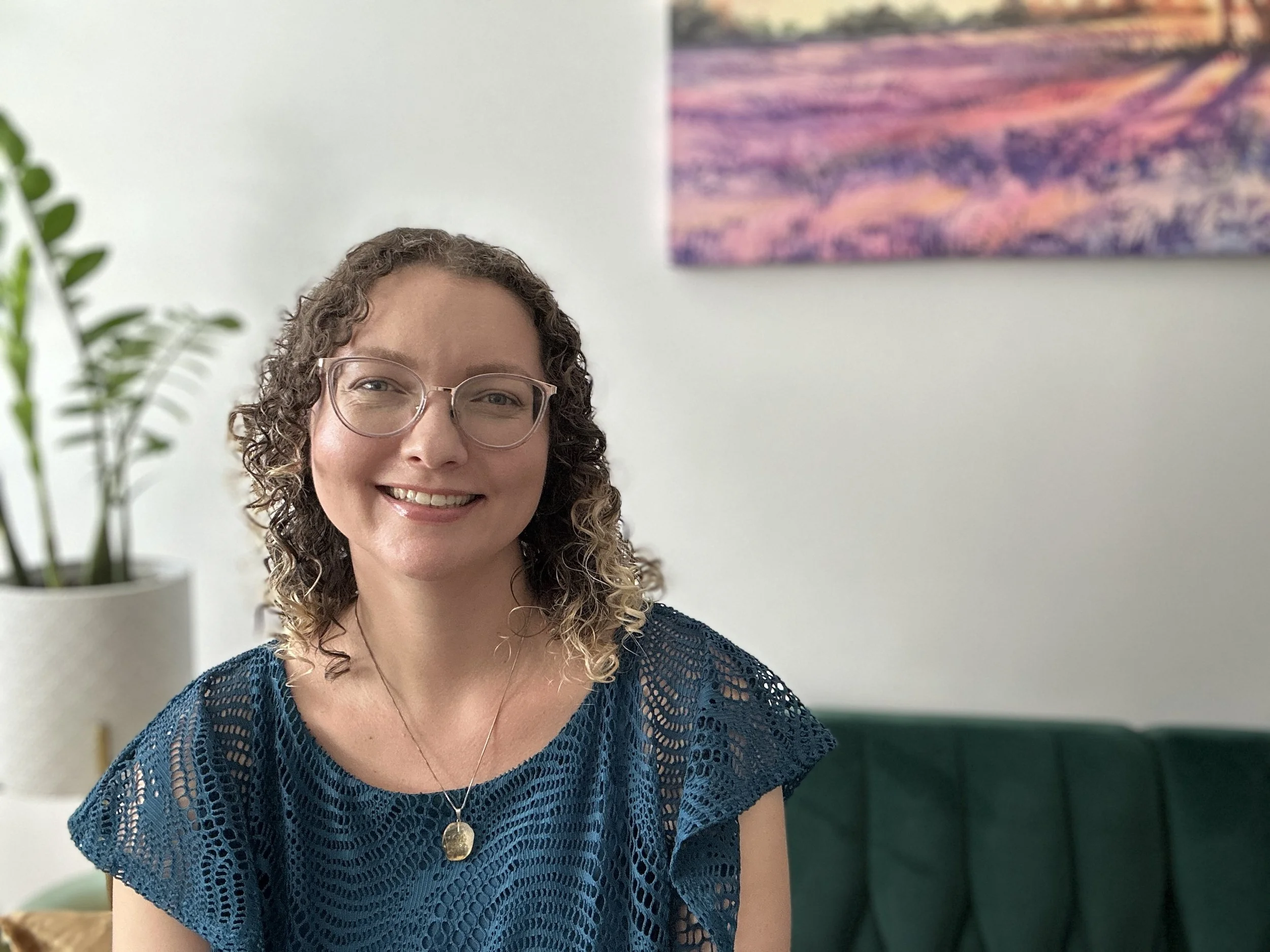 Alice Rizzi in a blue dress in her office; plant in background