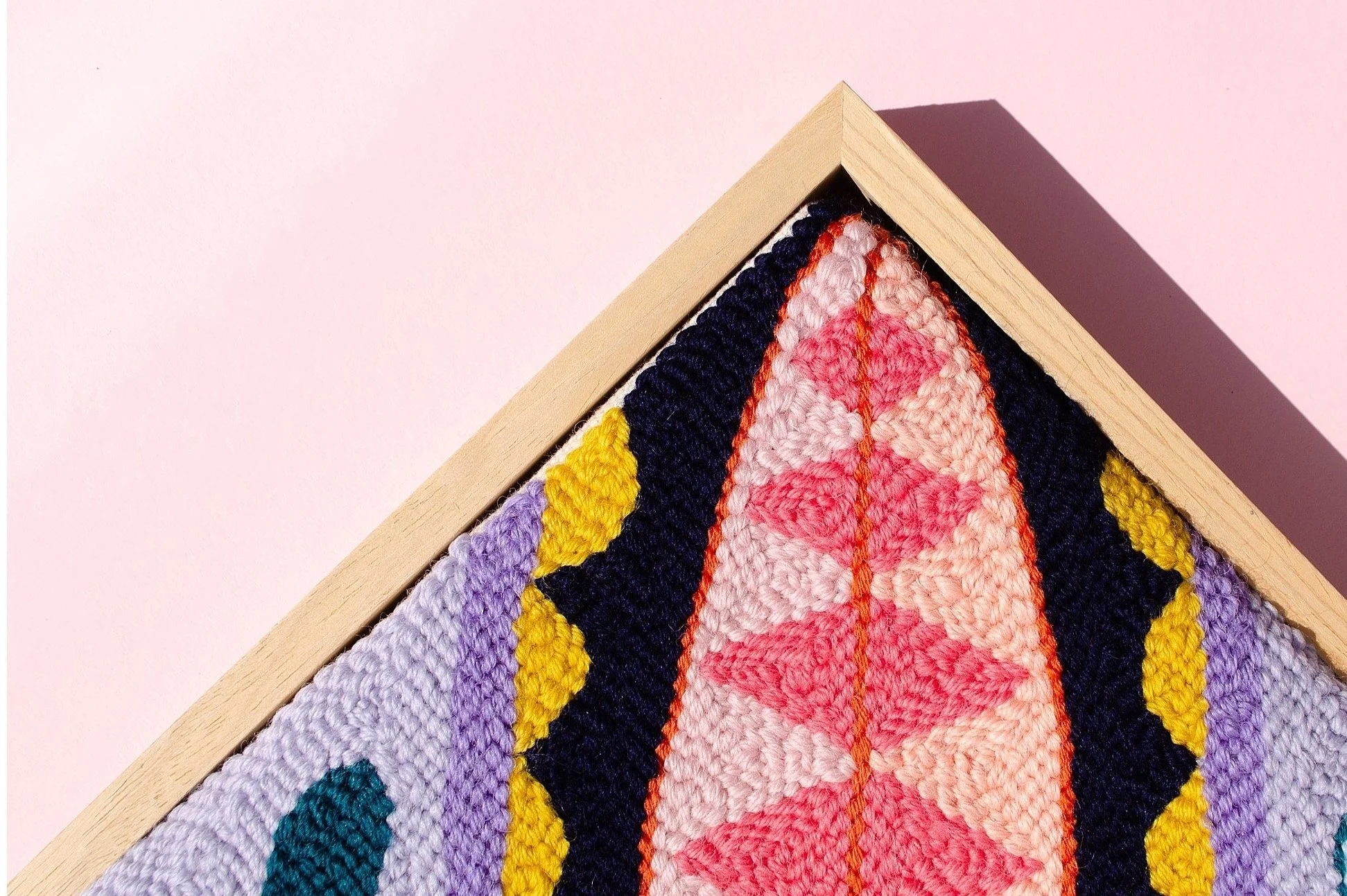 Close-up of hand-tufted wool artwork showing intricate Pacific patterns and textures.