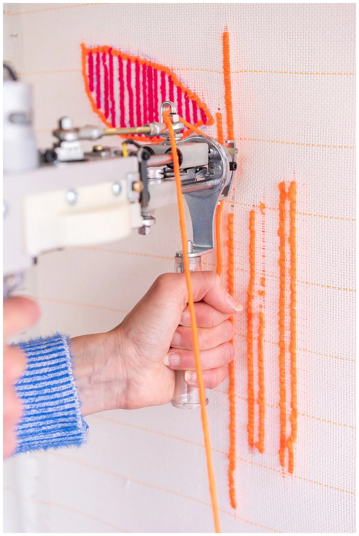 Natalie Holland tufting a wool textile piece with hiapo-inspired Pacific motifs.