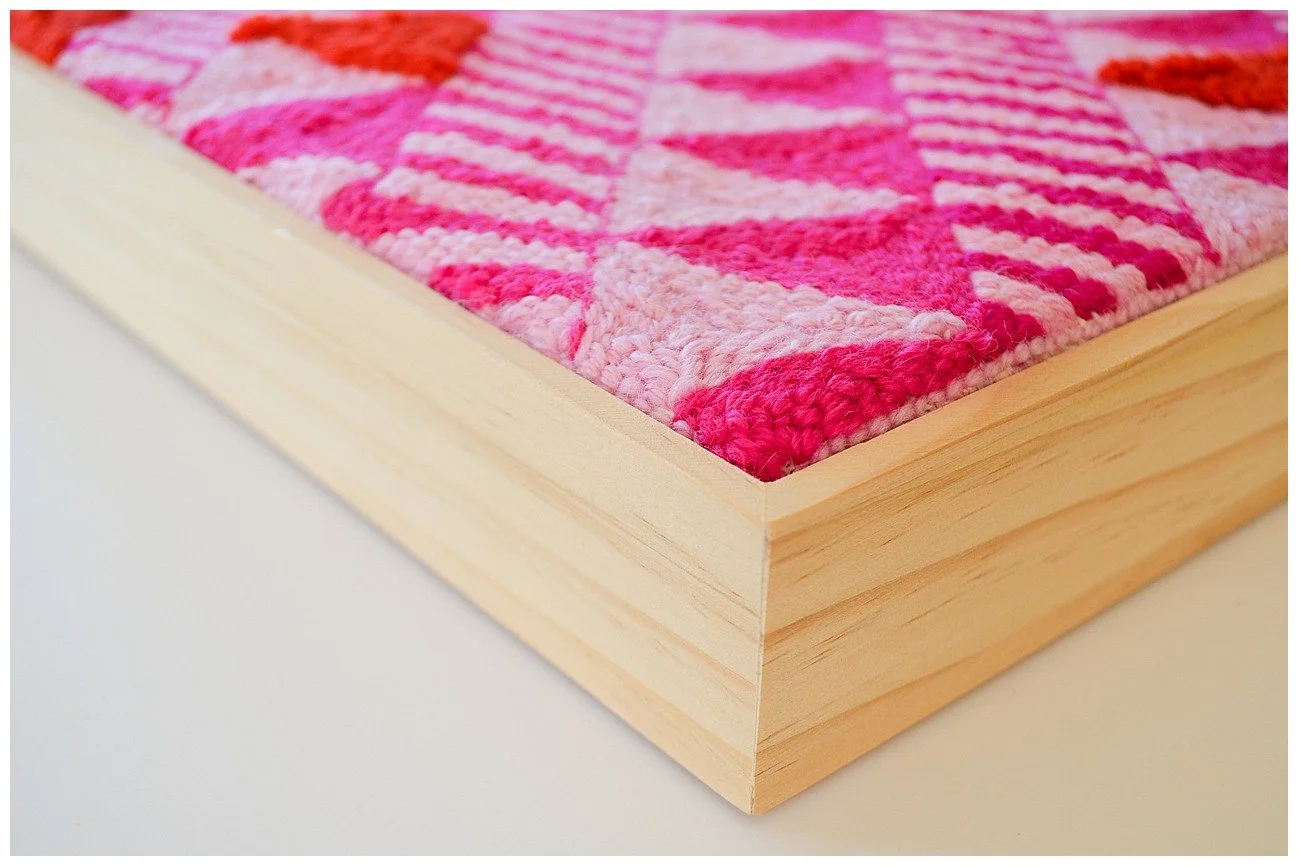 Punch needle textile artwork featuring contemporary Niuean hiapo-inspired motifs in colourful New Zealand wool.