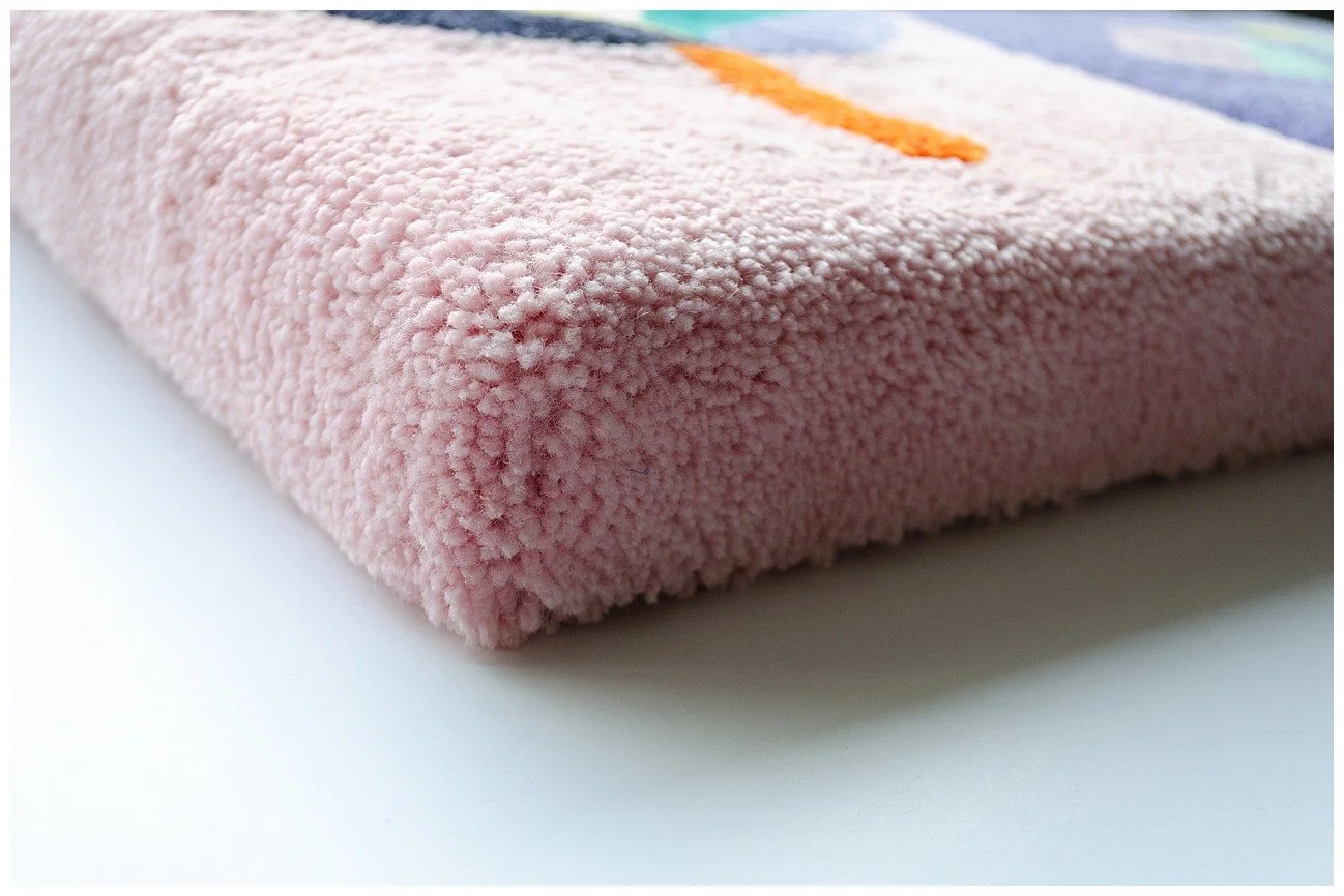 Detail of tufted wool textile showcasing fine Pacific-inspired pattern work and texture.