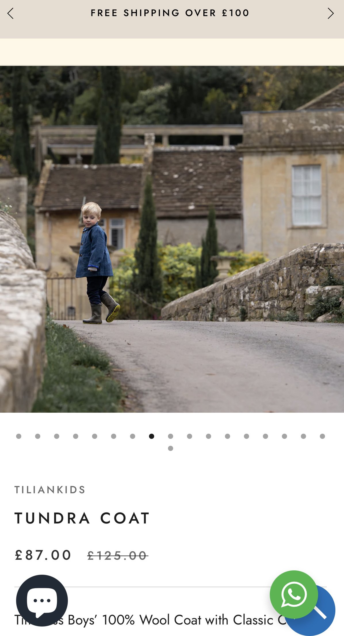A young boy walking outdoors on a paved path with old stone buildings and greenery in the background.