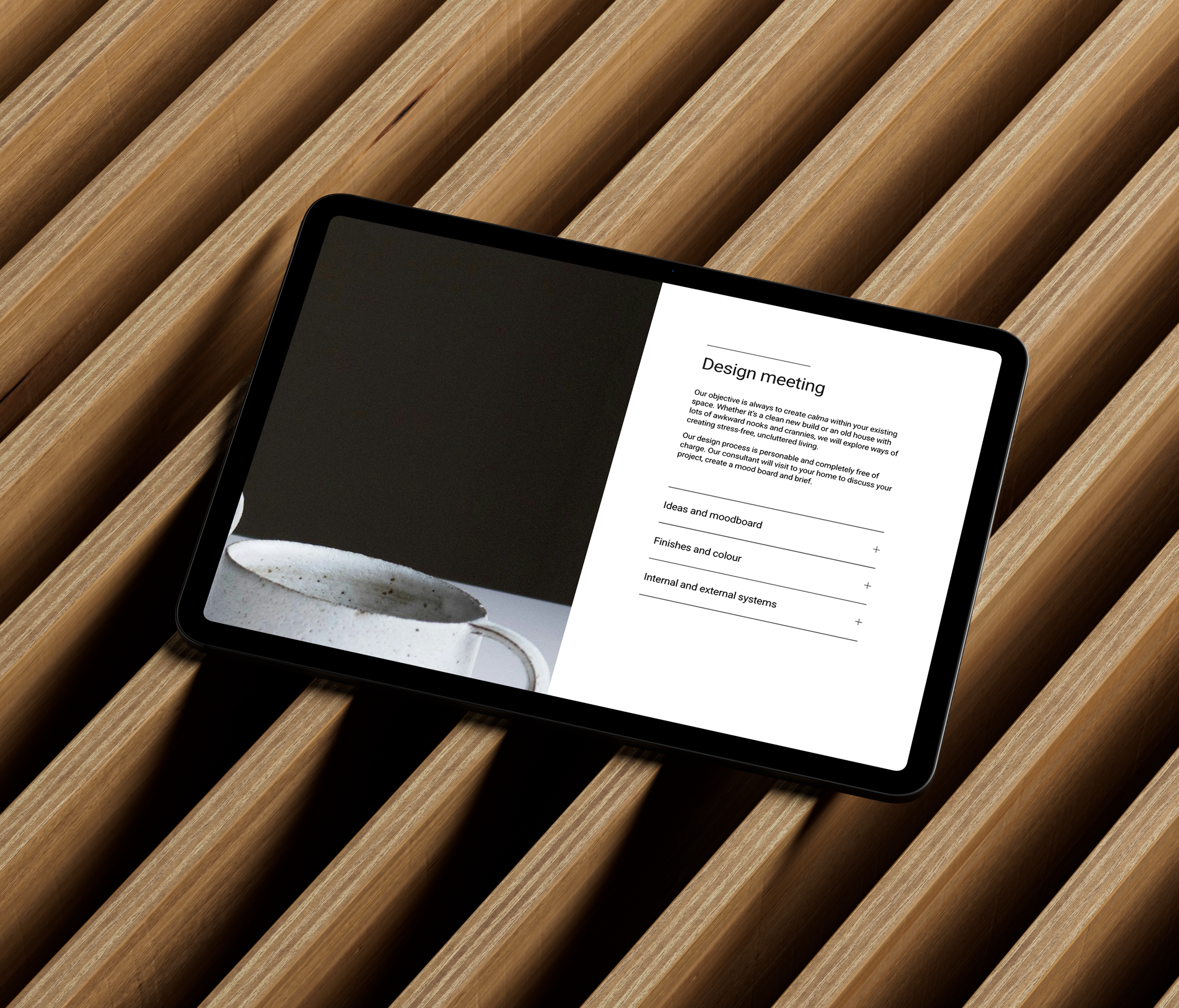 Tablet displaying a design meeting document on a wooden slatted surface.