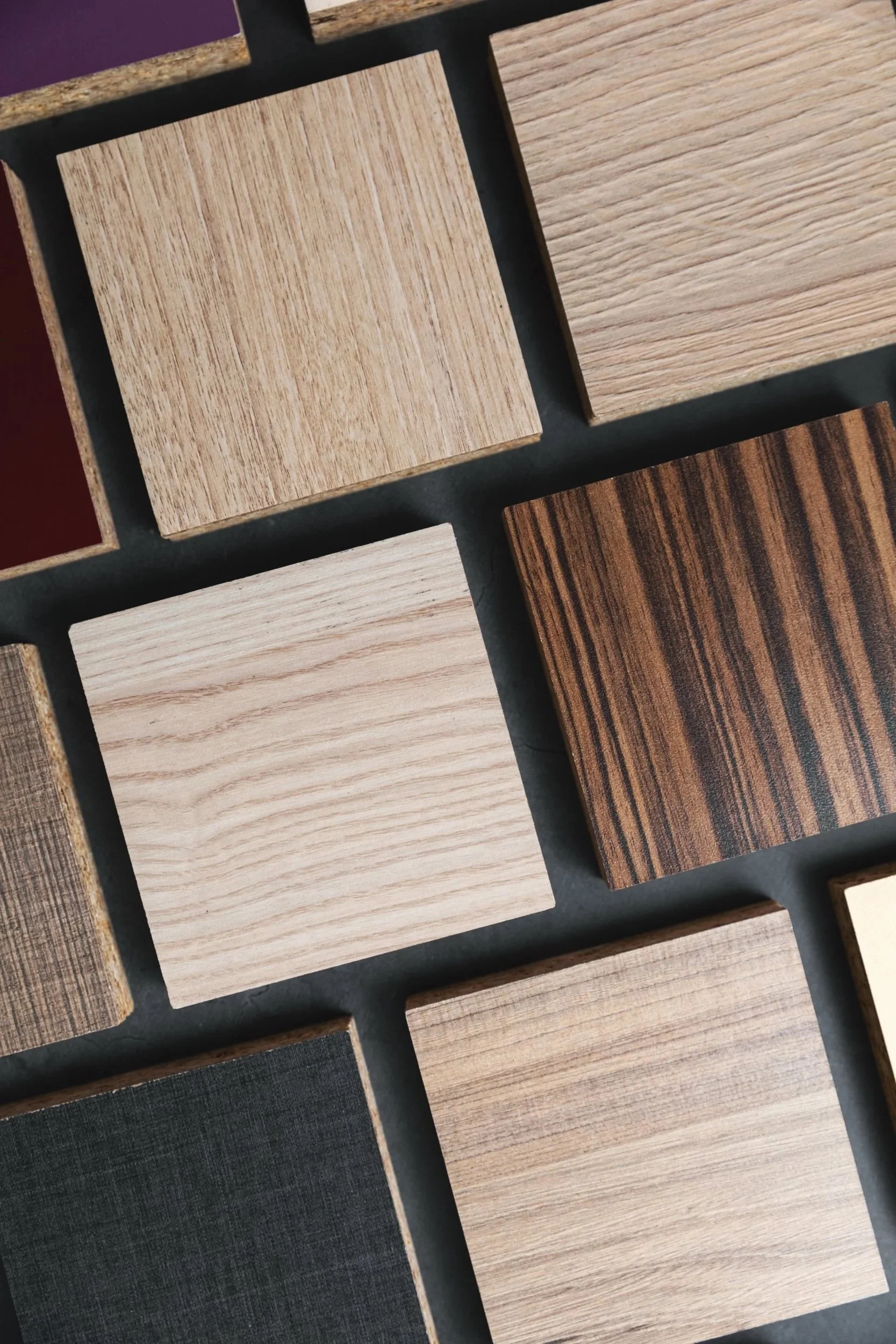 Collection of wooden square samples with different wood grain patterns and colors.