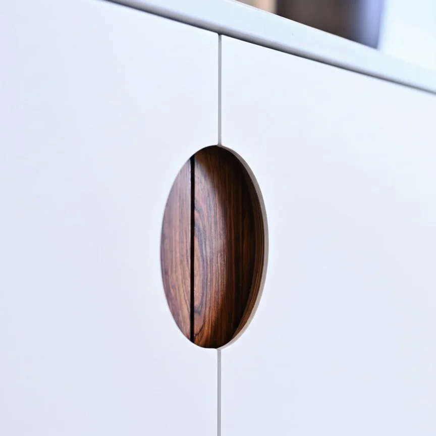 Close-up of a white cabinet with a circular cutout revealing a wooden interior