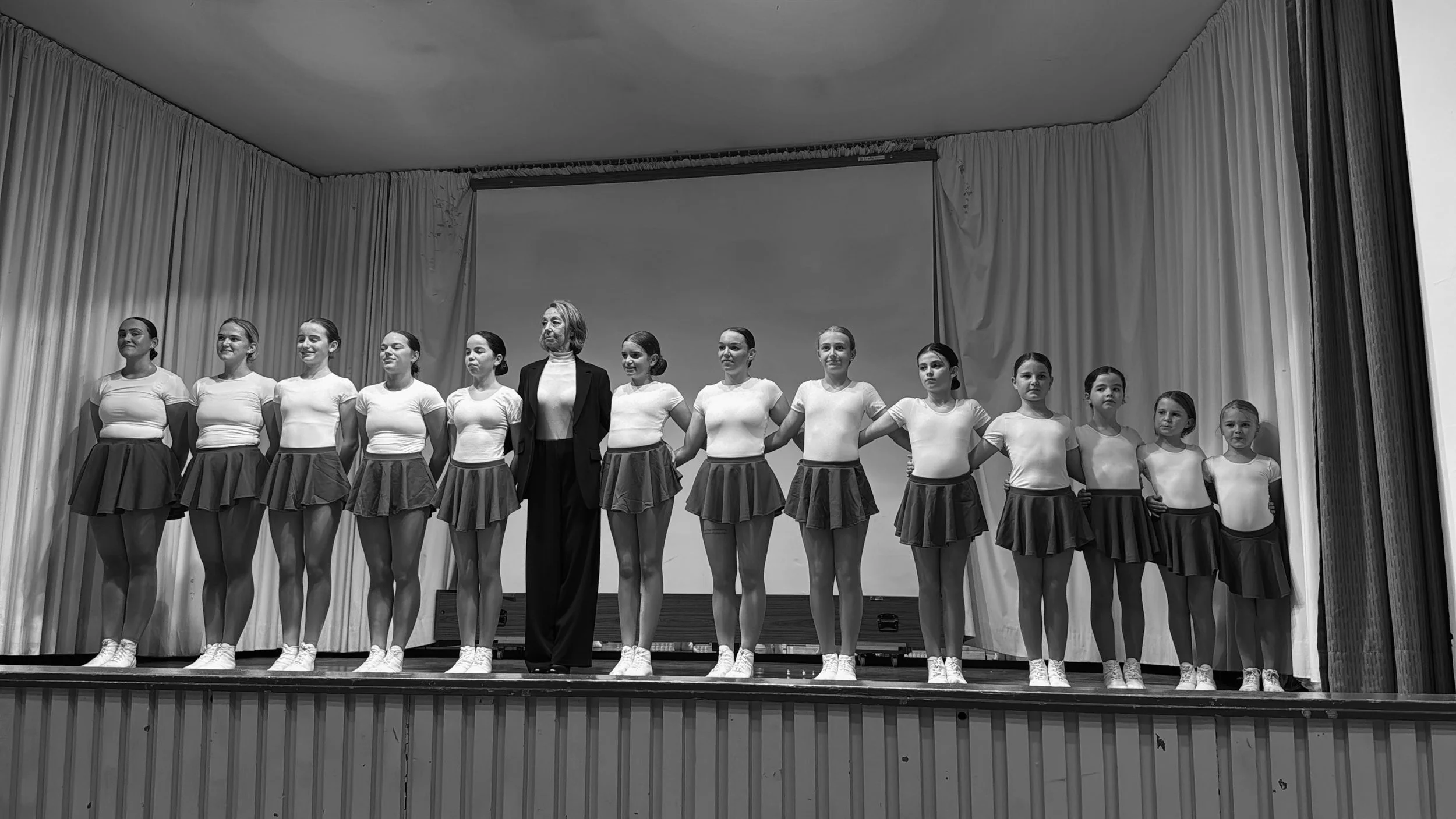 Die Tanzsportgarde Düsseldorf e.V. in Aufstellung auf der Bühne – Tänzerinnen in Trainingskleidung mit Trainerin in der Mitte.