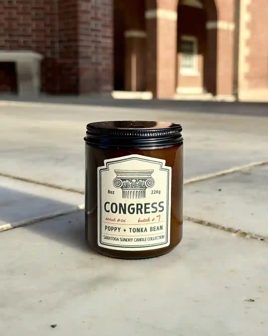 Congress soy candle in amber jar from Saratoga Sundry set in the Hall of Springs.webp