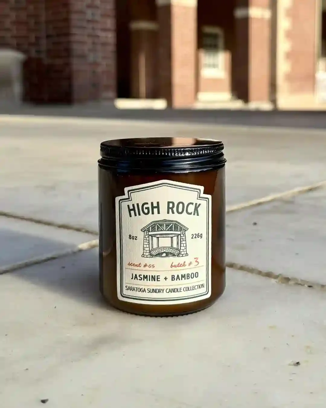 High Rock soy candle in amber jar from Saratoga Sundry set in the Hall of Springs.webp
