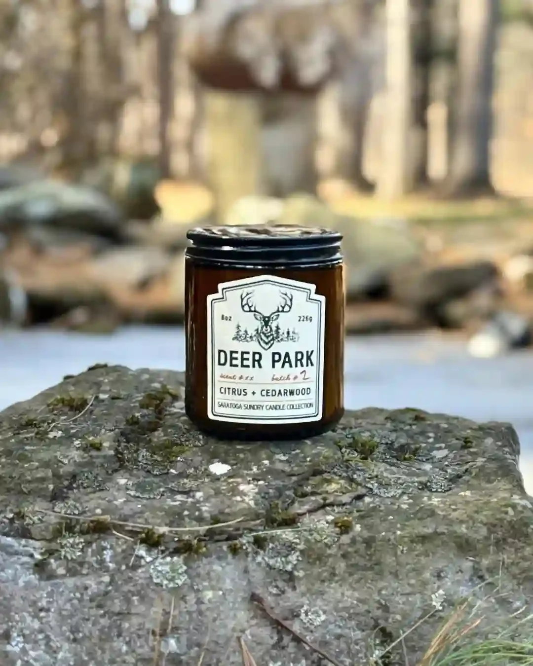 Deer Park Saratoga Sundry candle on a rock.webp