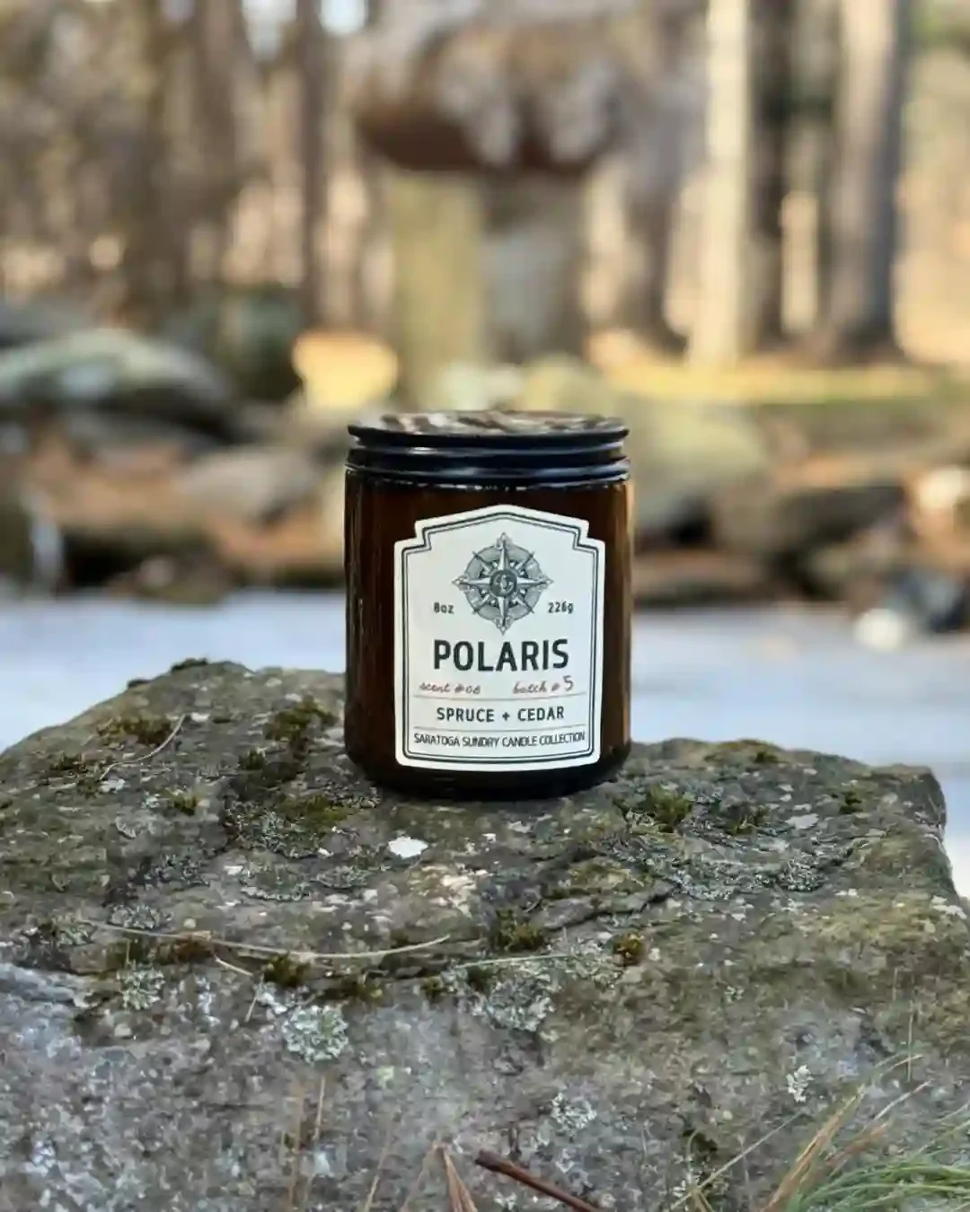 Polaris Saratoga Sundry candle on a rock.webp