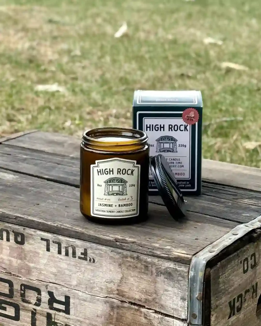 High Rock candle and gift box from Saratoga Sundry sitting on a wooden antique High Rock Water crate.webp
