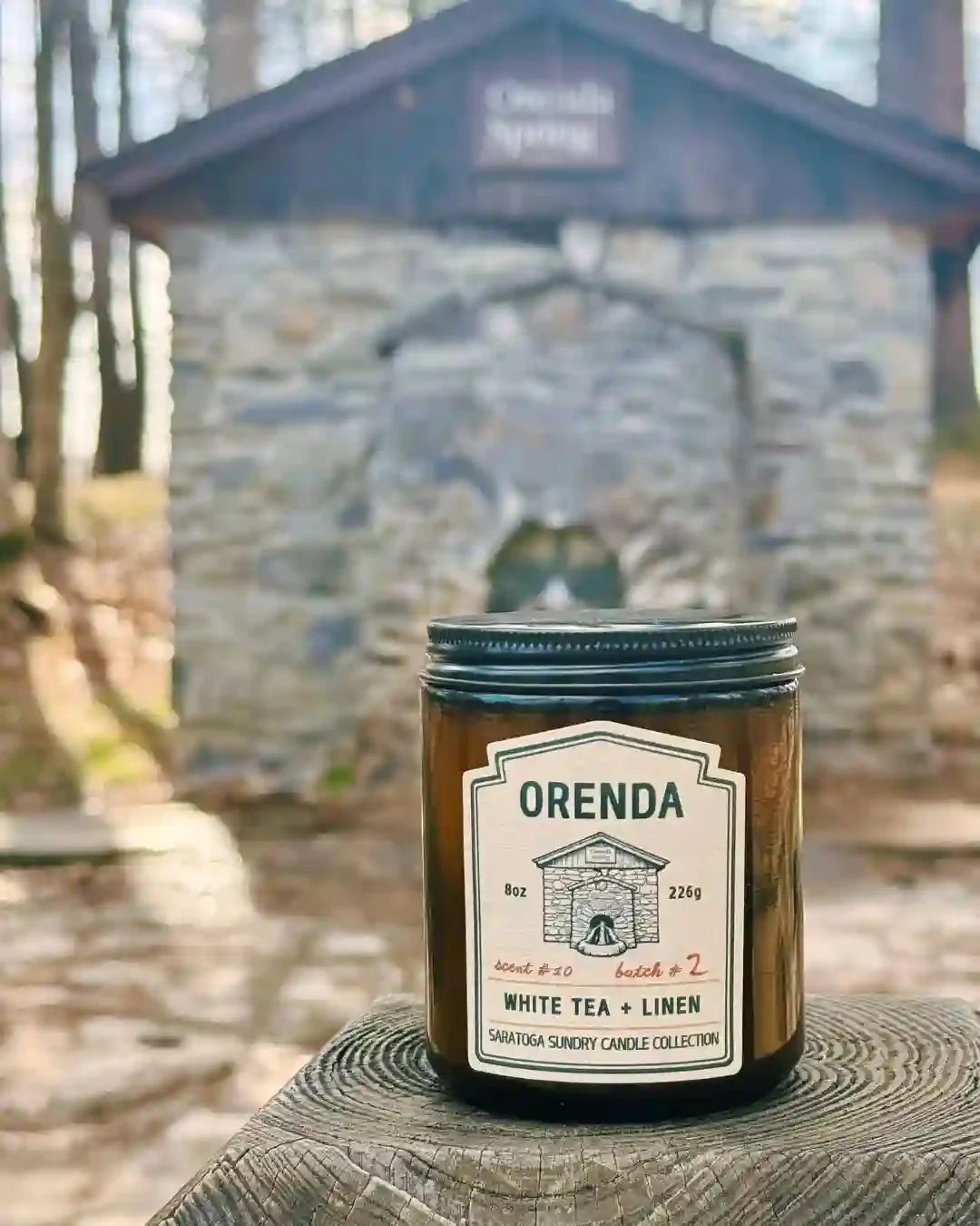 Orenda candle from Saratoga Sundry shot in front of the Orenda Spring in Saratoga Springs NY.webp