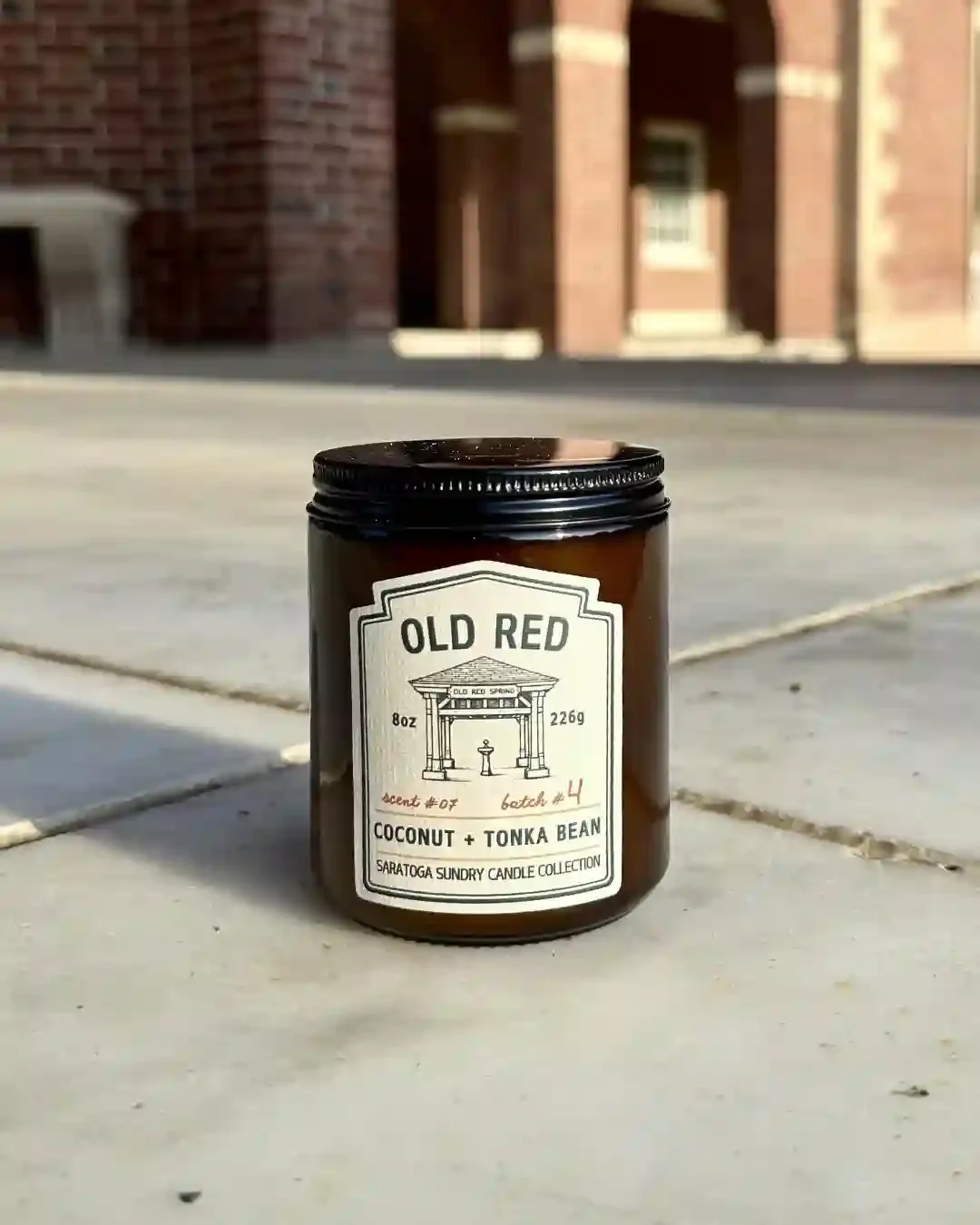 Old Red soy candle in amber jar from Saratoga Sundry set in the Hall of Springs.webp