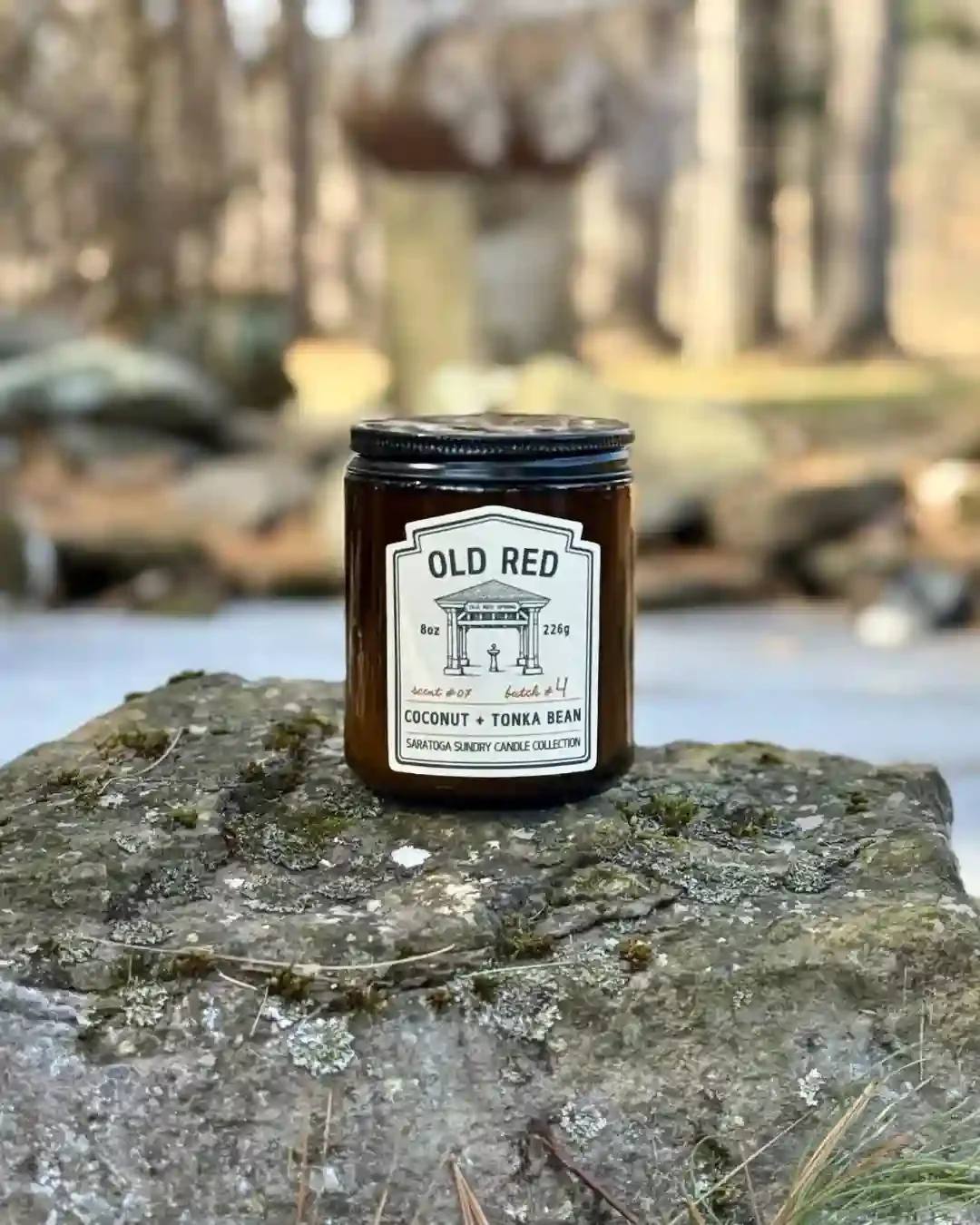 Old Red Saratoga Sundry candle on a rock.webp