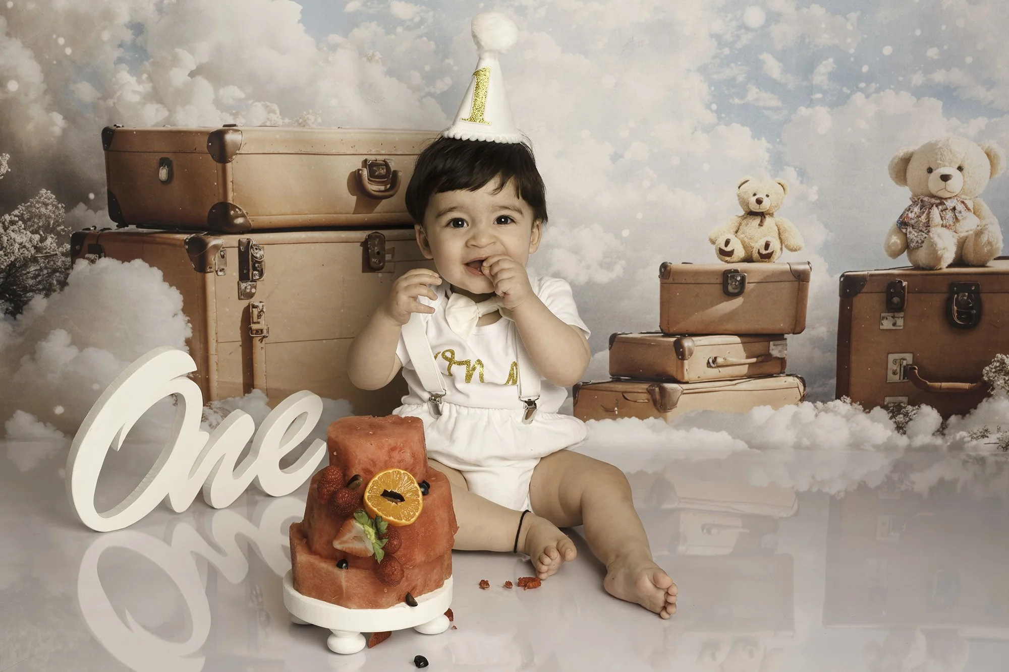 one year boy cake smash photo with a watermelon cake and hotair balloon theme background