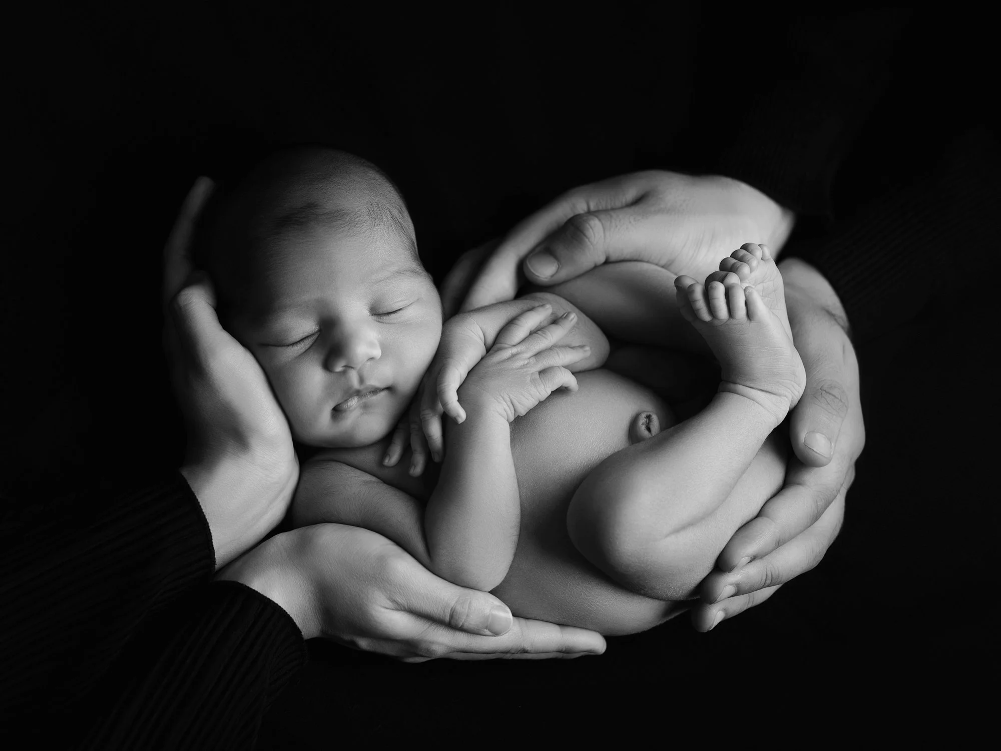 b7w picture of a newborn baby in parents hands
