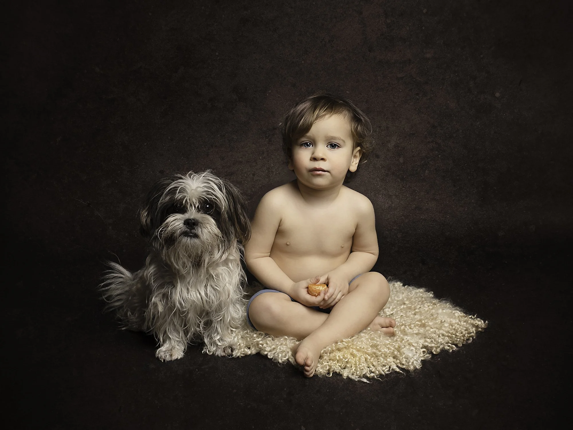 toddler sitting next to a dog with brown art background 