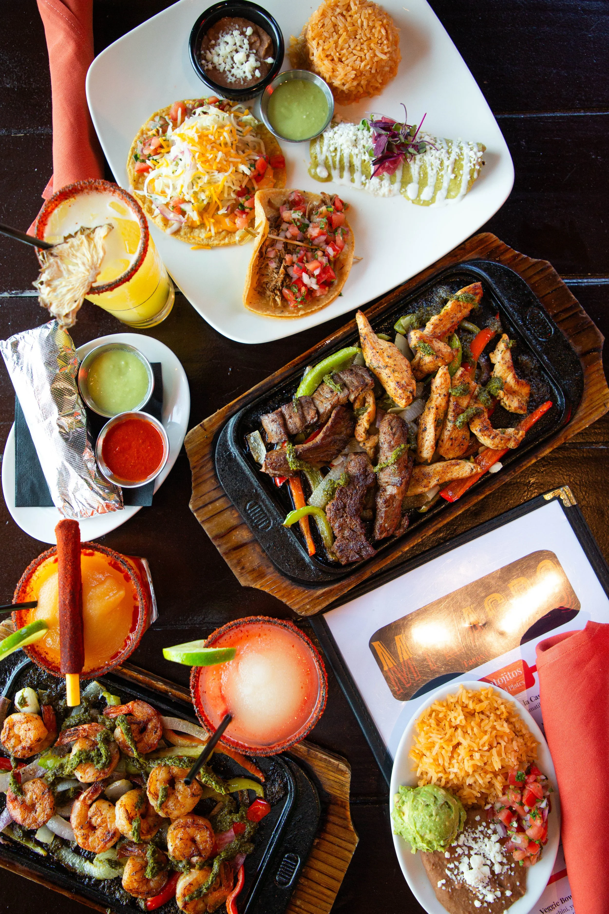 Fajitas and street tacos and margaritas on the table at Milagro Taco Cantina in Dallas