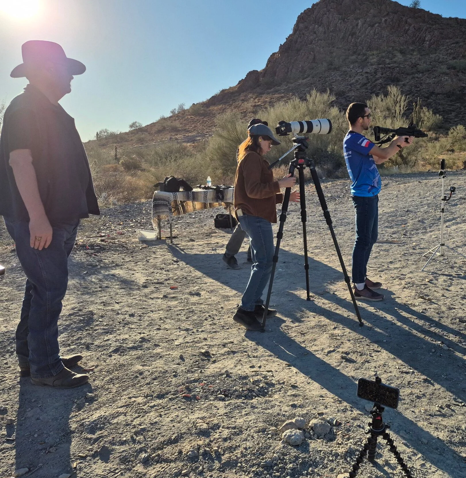 Arizona Tomasz and Navy Seals shooting guns in the mountains. Melissa adjusting camera.