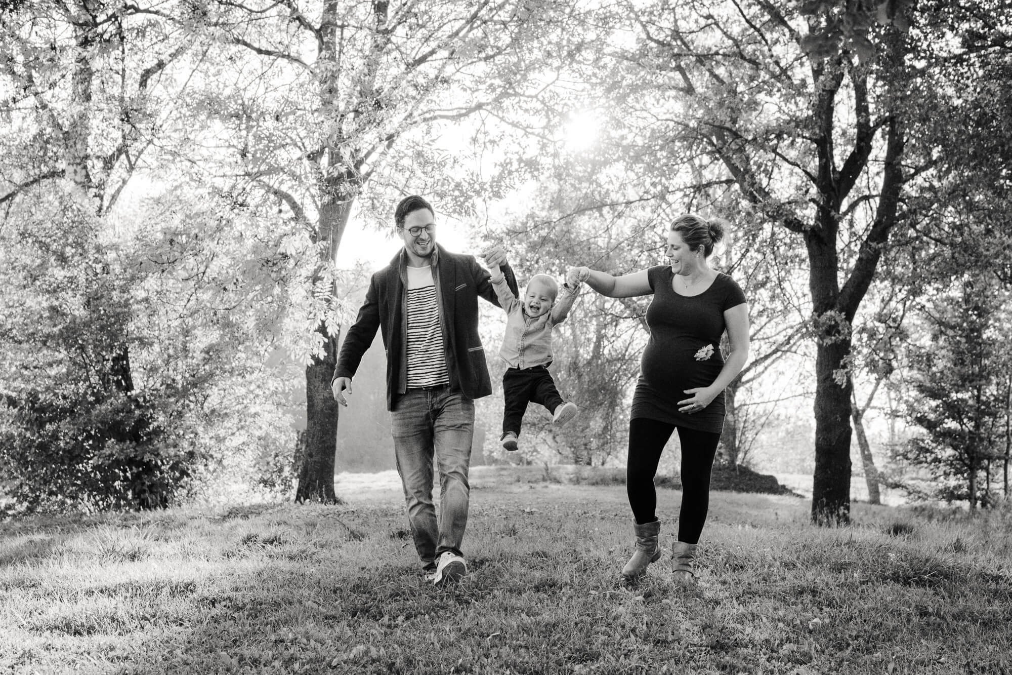 Familia caminando junta en blanco y negro, fotografía emocional y natural de embarazo en Cantabria.