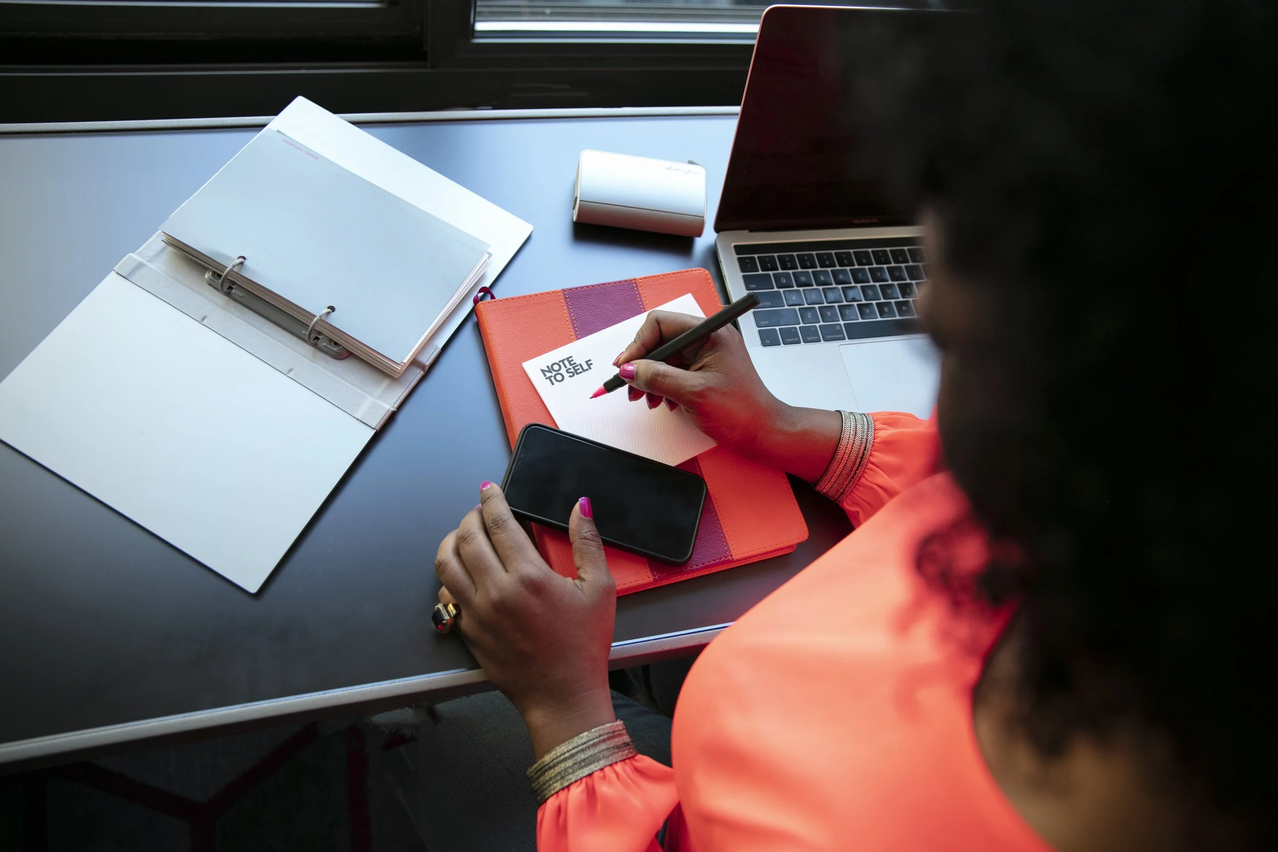 Senior leader taking notes at a desk during a reflective planning session
