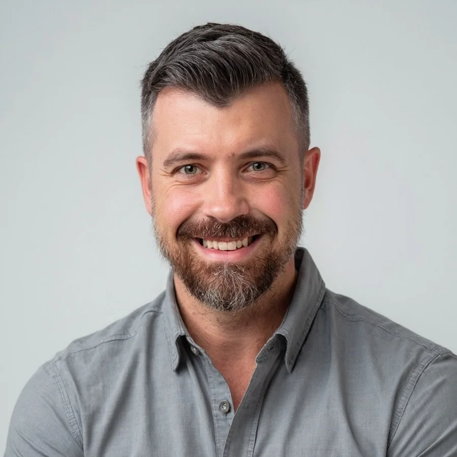 David Vaughn - General Manager of Refuge Roofing with short brown hair, a beard, wearing a gray button-up shirt against a plain light background.