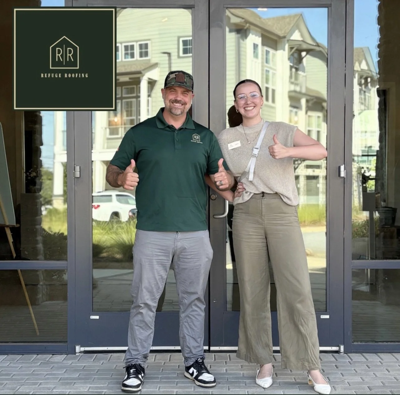 A man and a woman standing in front of a glass door, smiling and giving thumbs-up. The man is wearing a dark green polo shirt, light gray pants, and a camouflage cap. The woman has glasses, a beige sleeveless top, beige pants, and a white purse. There is a logo for Refuge Roofing on the upper left corner of the image.
