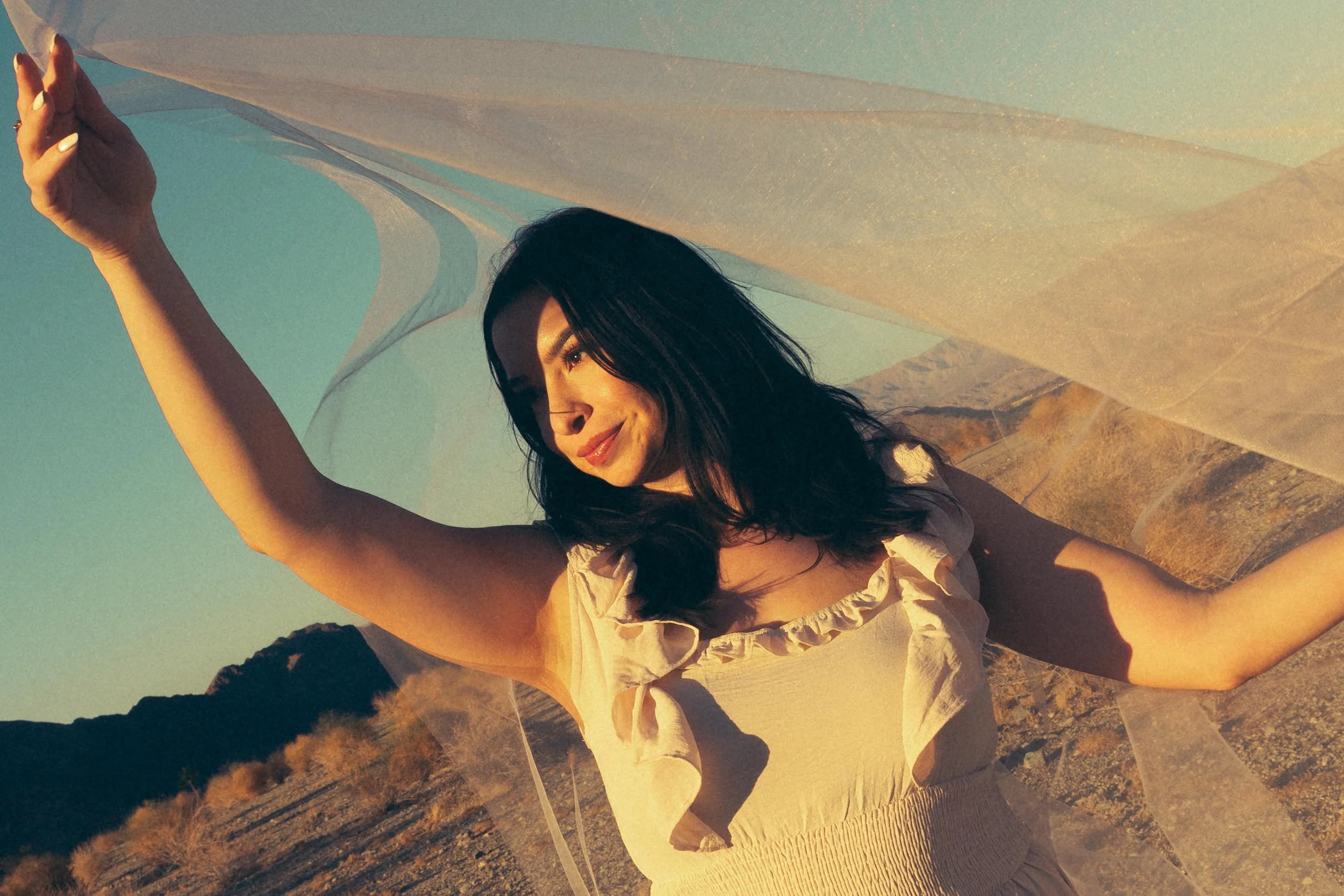 Founder of Nurture The Divine and holistic birth doula Kalista Zubiate standing in a desert landscape.