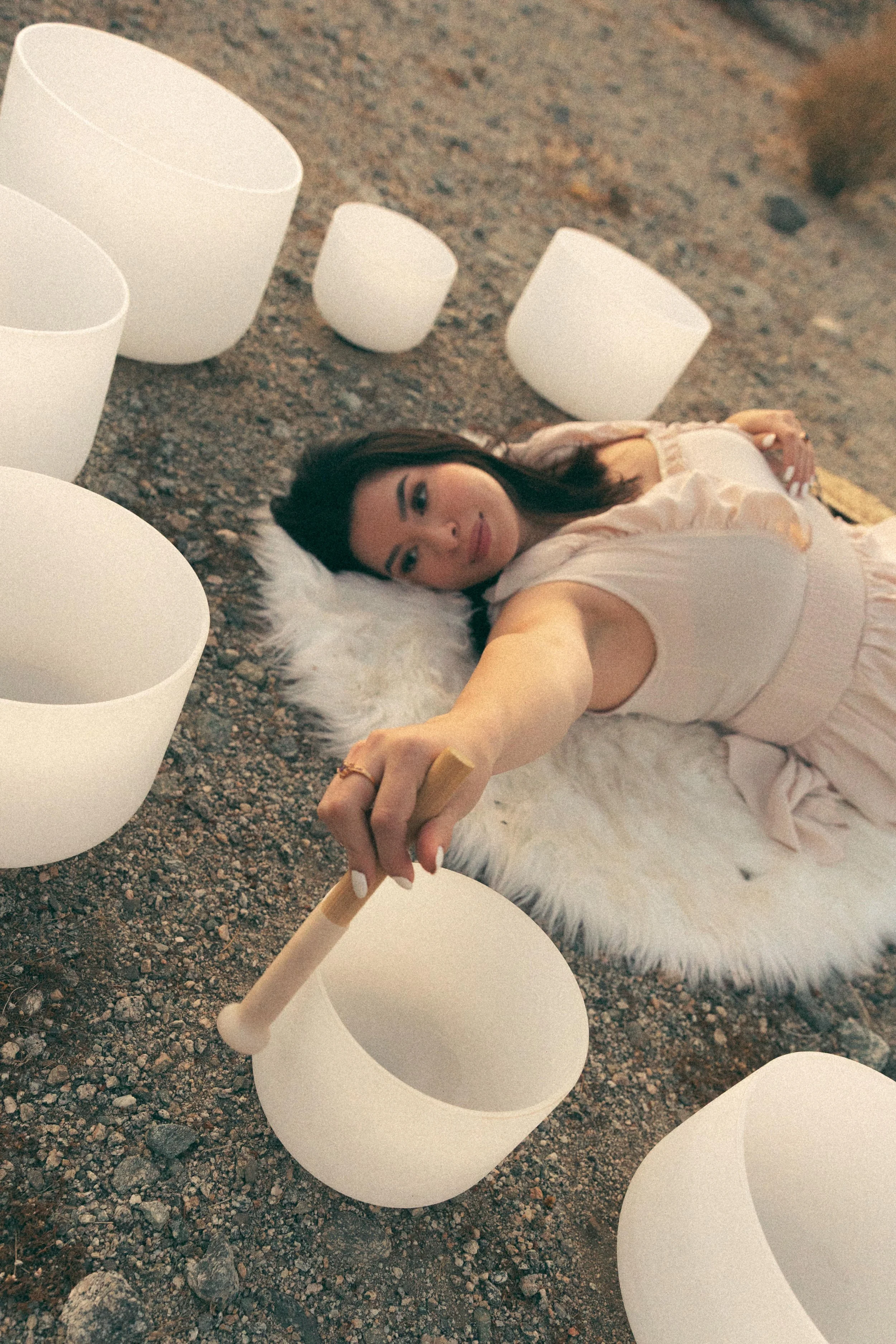 Birth doula Kalista Zubiate lays on the ground while practicing a private sound bath meditation in the desert.