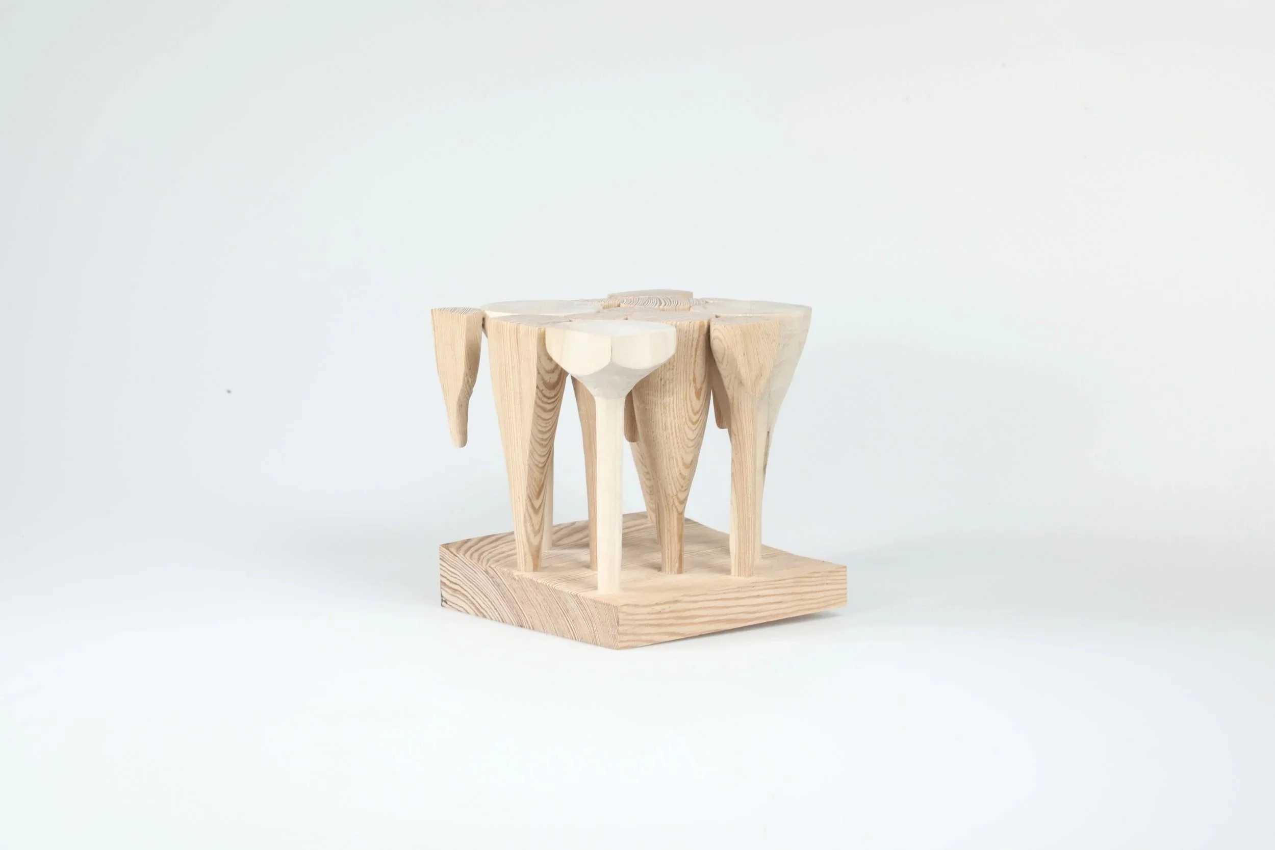 Wooden chair with a minimalist design, featuring a square base and curved legs, set against a plain white background.