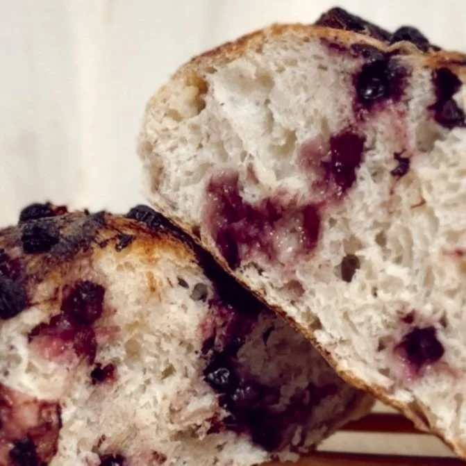 Close-up of a sliced blueberry bread showcasing its soft, airy texture and visible blueberries.
