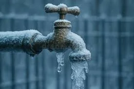 Frozen outdoor faucet with snow and ice buildup.