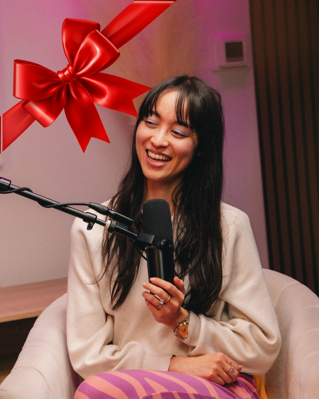 Podcaster talking into mic with a holiday bow