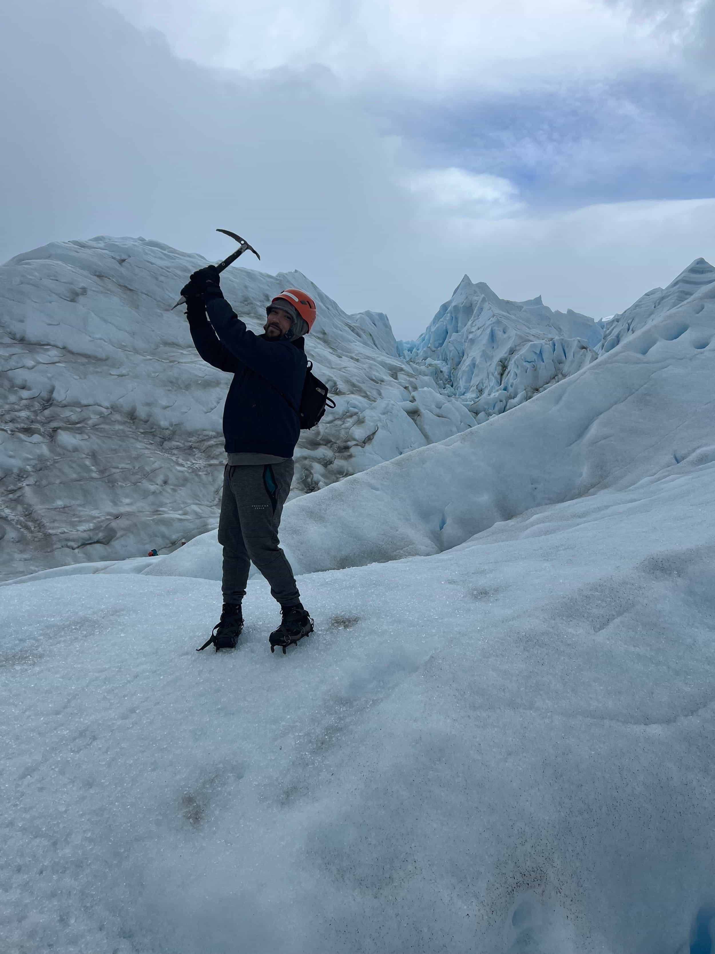 Carlos hiking on a snowy mountain with an ice pick
