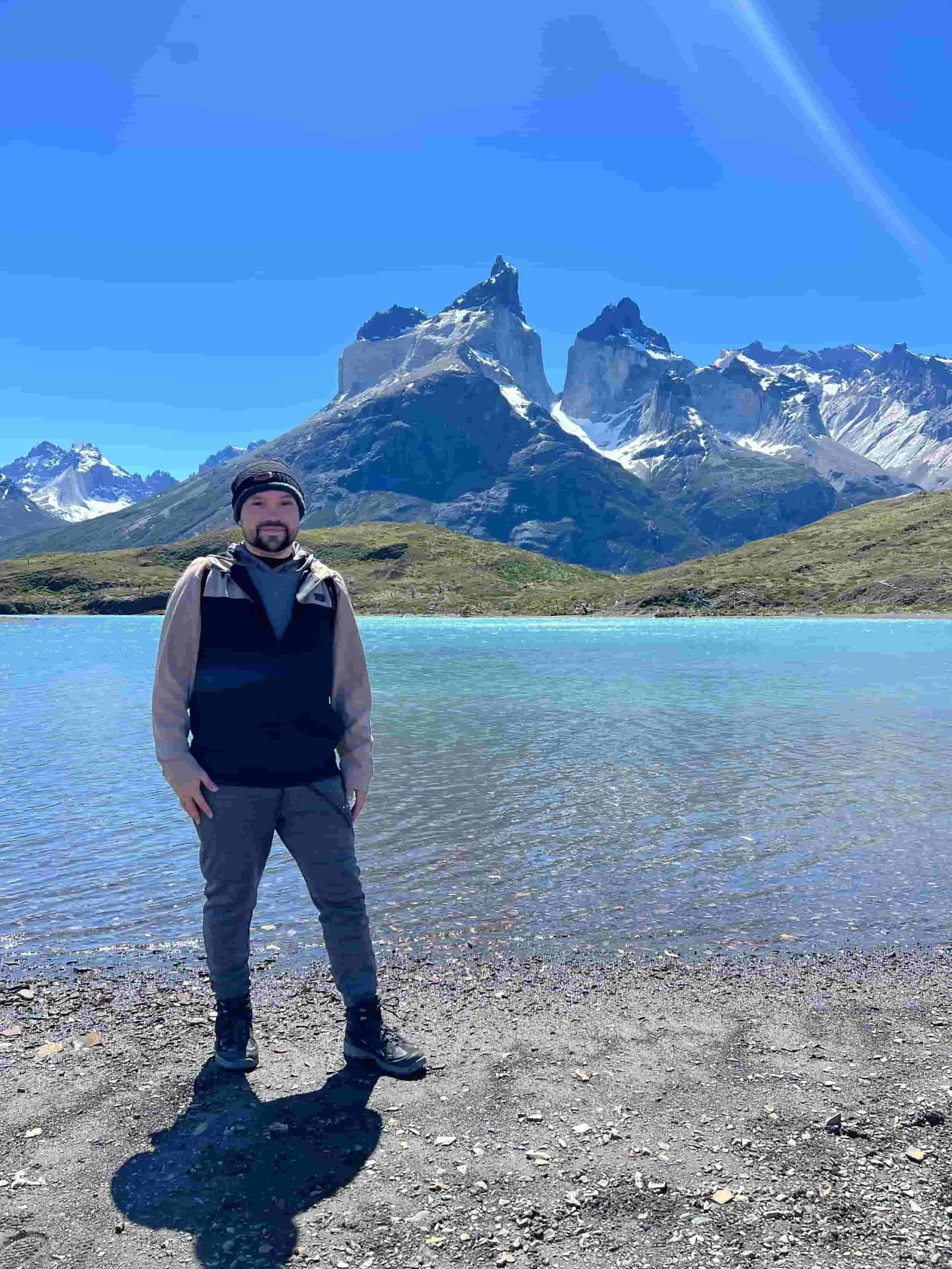 Carlos on a hike in front of a beautiful mountain lake