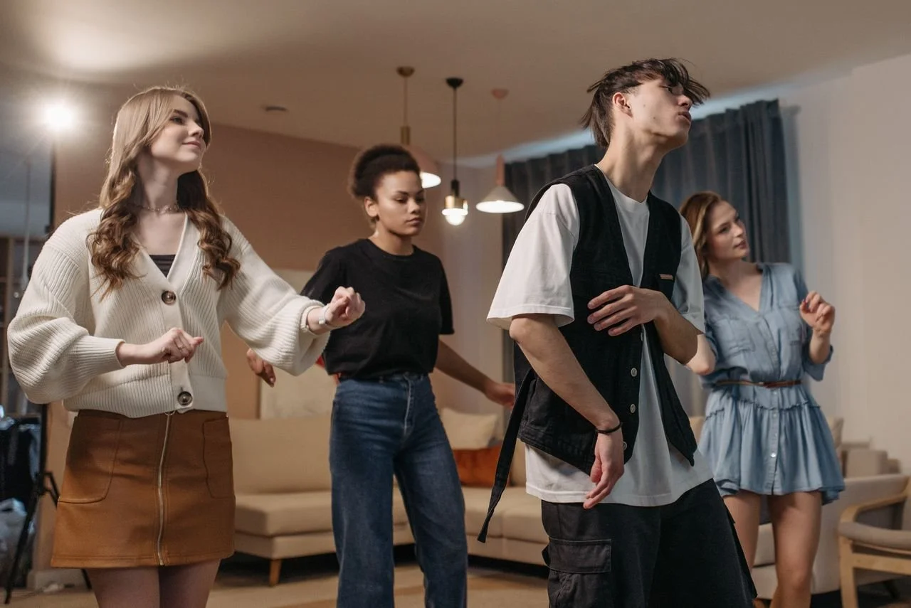 A group of four people dancing on a stage