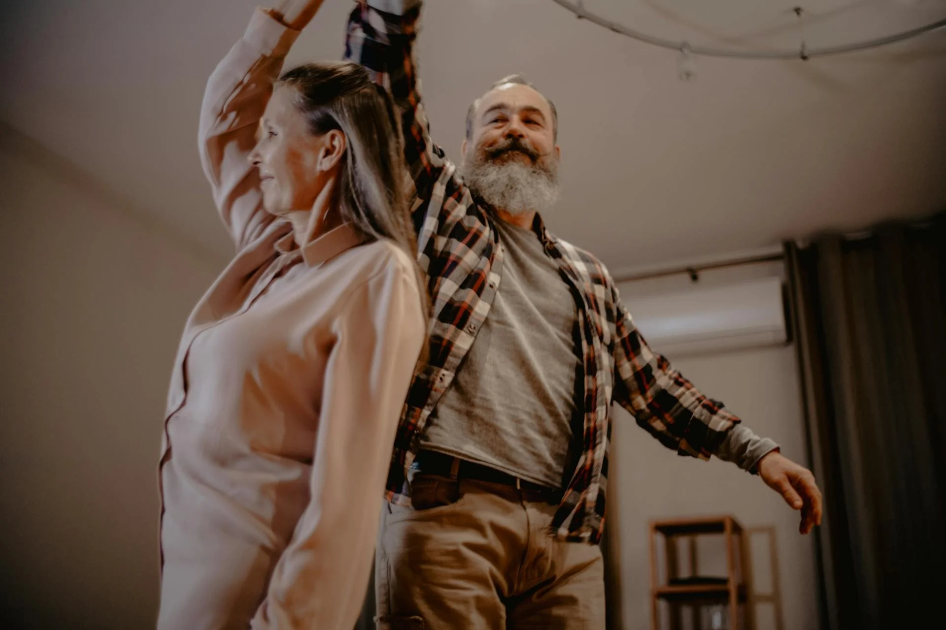 An elderly couple happily dances together