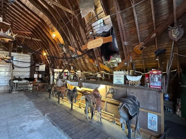 Licensed bar area at Top Gun Saloon featuring handcrafted saddle bar stools and western inspired decor
