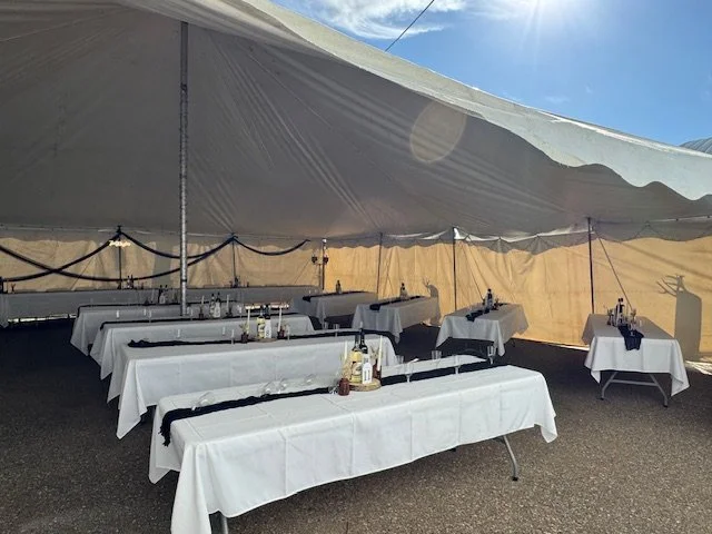 Wedding reception tables decorated with centerpiece inside the event tent.