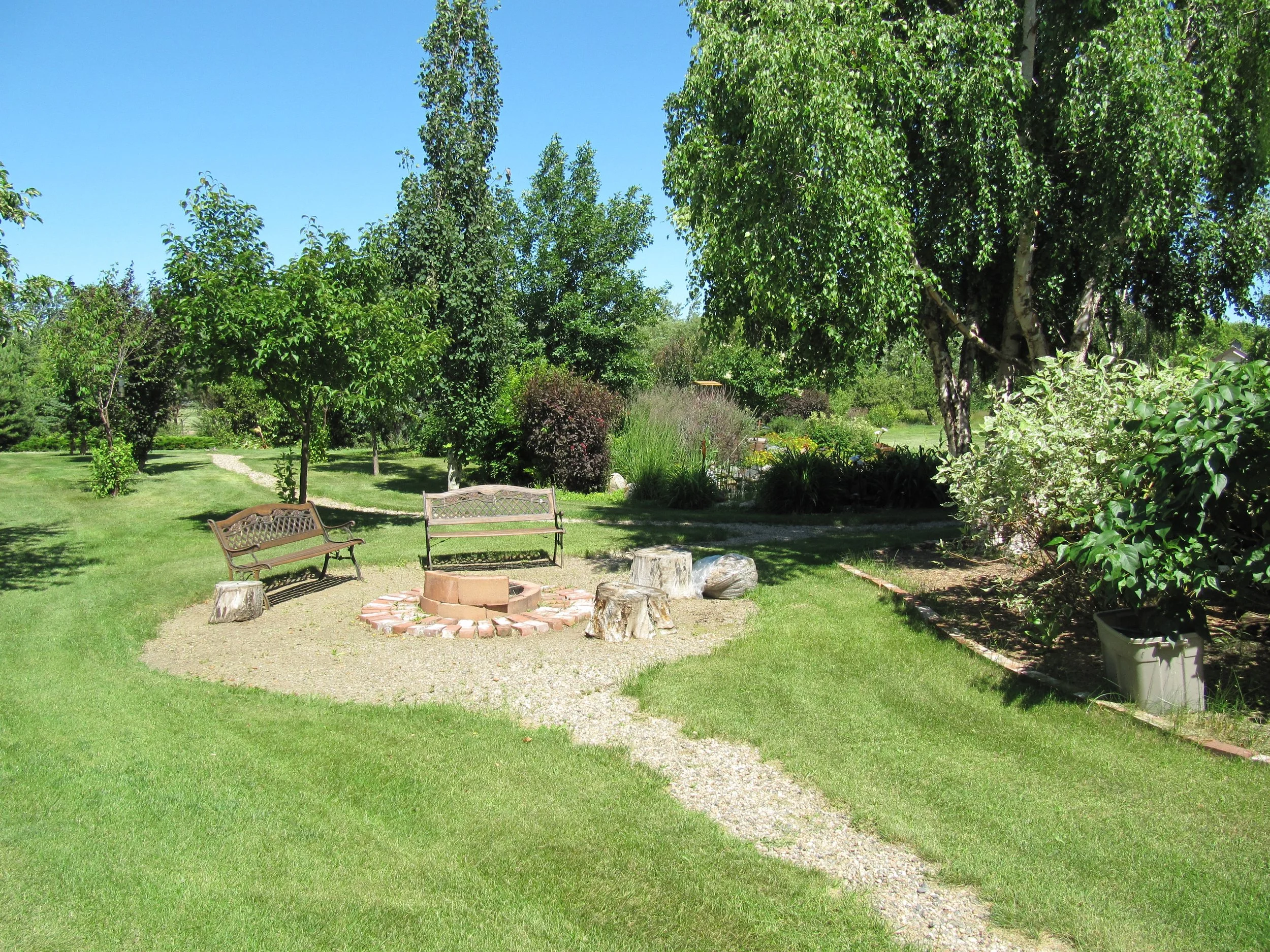 Gravel walkway leading past the fire pit to the outdoor reception area